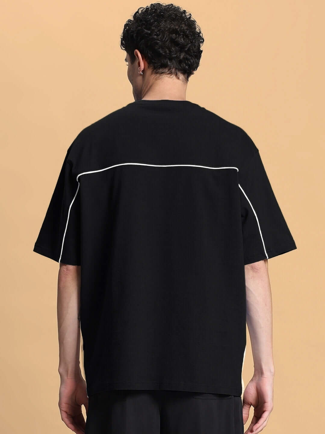 Back view of INDY OVER-SIZED CLASSIC T-SHIRT BLACK on a model showcasing premium cotton fabric and streetwear style.