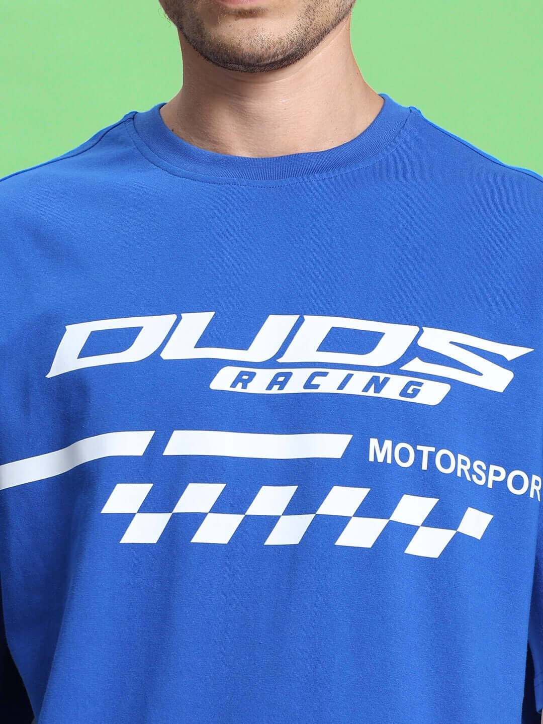 Close-up of blue racing-themed t-shirt with white graphics, showcasing casual fashion.
