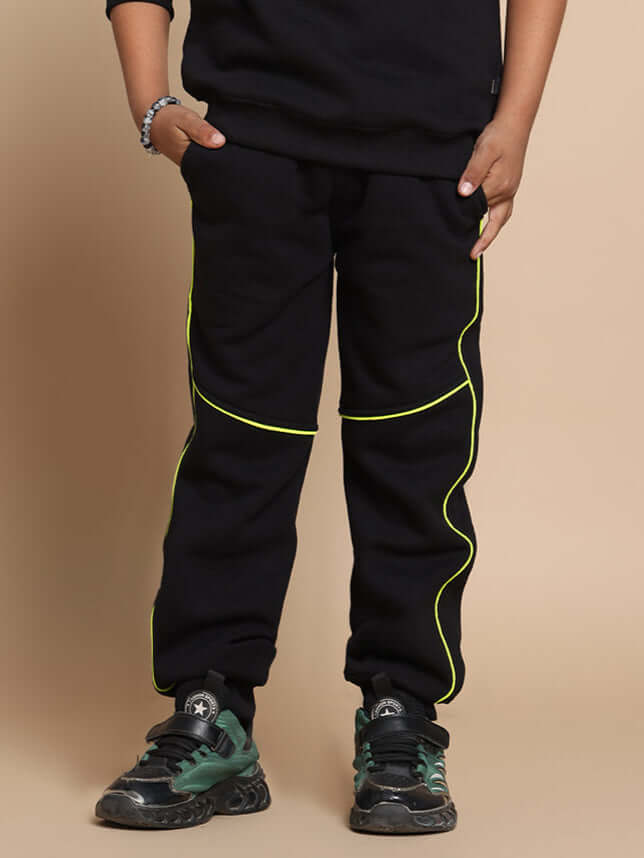 Child wearing black jogger pants with neon yellow accents, suitable for both boys and girls, showcasing stylish and comfortable design.