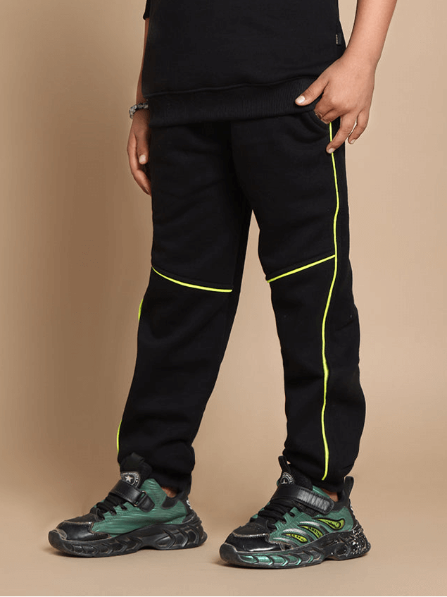 Child wearing black Innocent Fleece Co-ord Set with neon accents, showcasing stylish unisex jogger pants suitable for playtime.