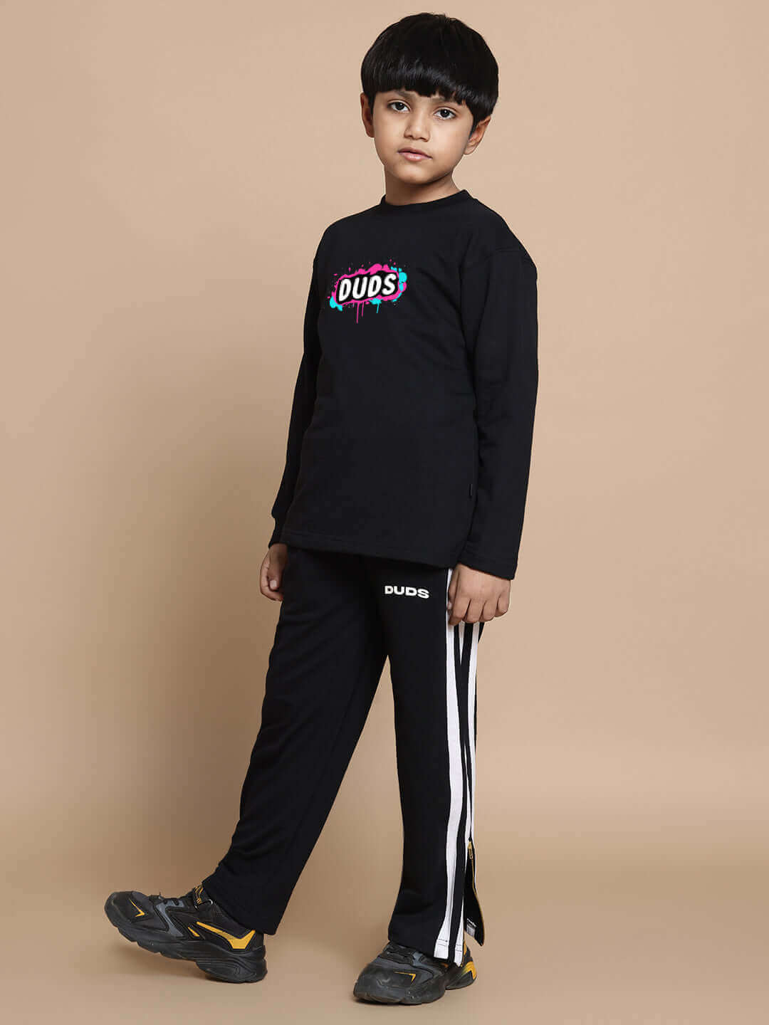 Young boy in a black unisex INSANE RABBIT co-ord set with joggers and long-sleeve top, featuring elastic waistband and premium cotton fabric.