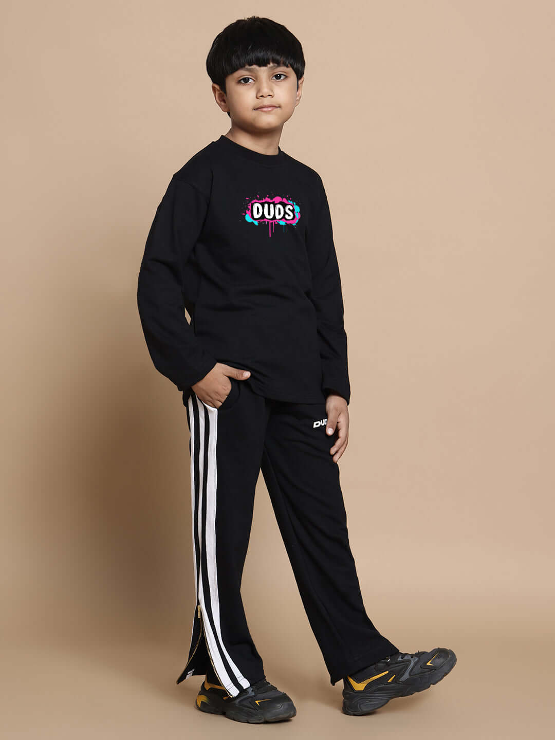Child wearing black unisex INSANE RABBIT co-ord set with elastic joggers, styled with white stripes, showcasing premium cotton fabric.