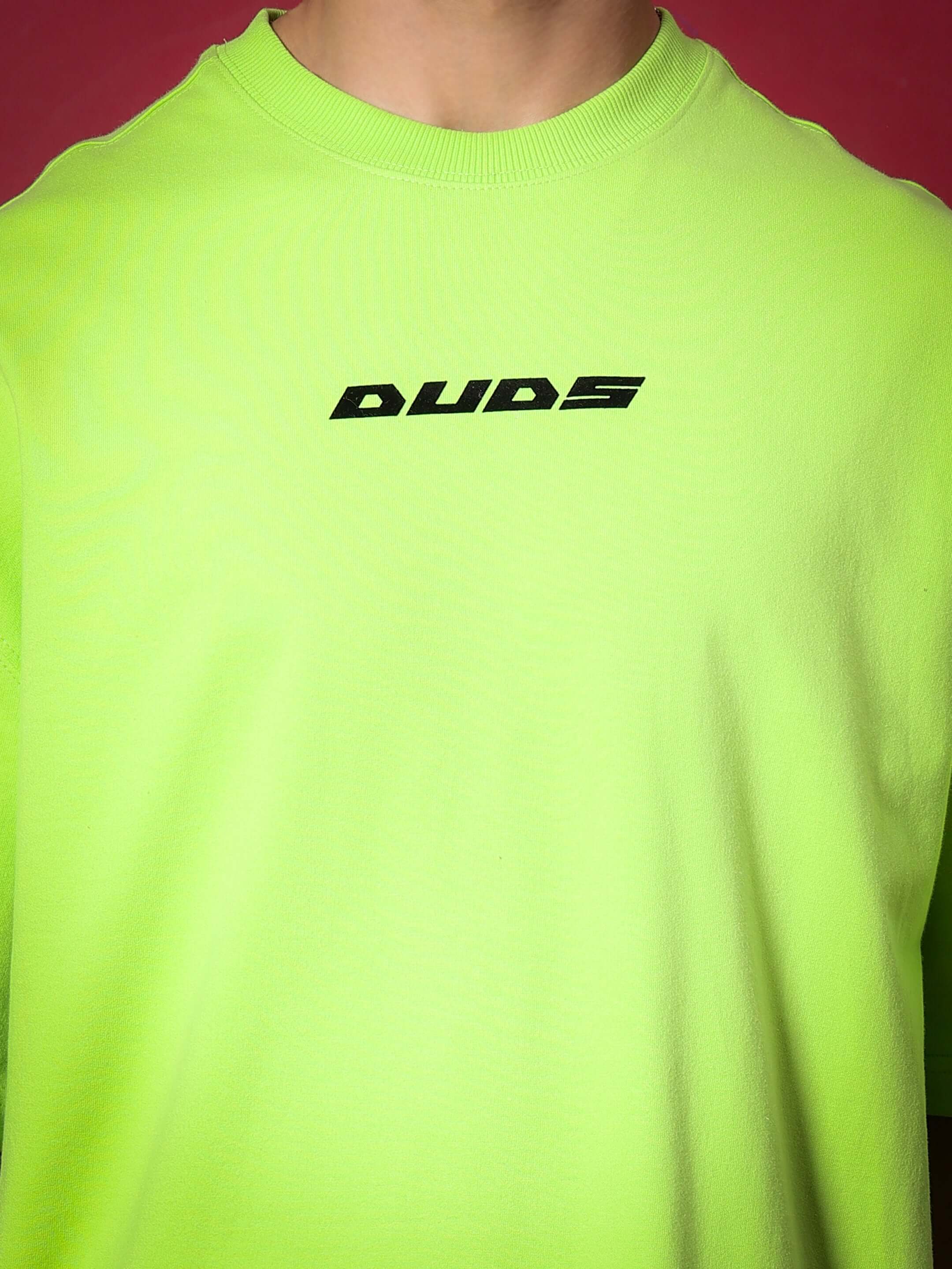 Neon green oversized t-shirt with "DUDS" logo, made from premium heavy gauge fabric, showcasing stylish and comfortable streetwear fashion.