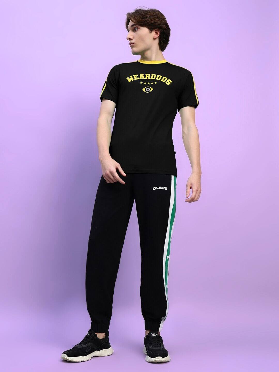 Person wearing Irish Regular Fit T-Shirt Black with crew neck and short sleeves on a purple background.