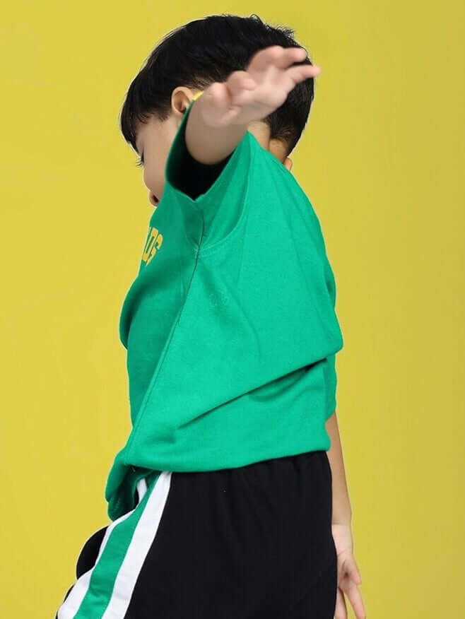 Child wearing IRISH T-SHIRT FOR BOYS AND GIRLS GREEN against yellow background