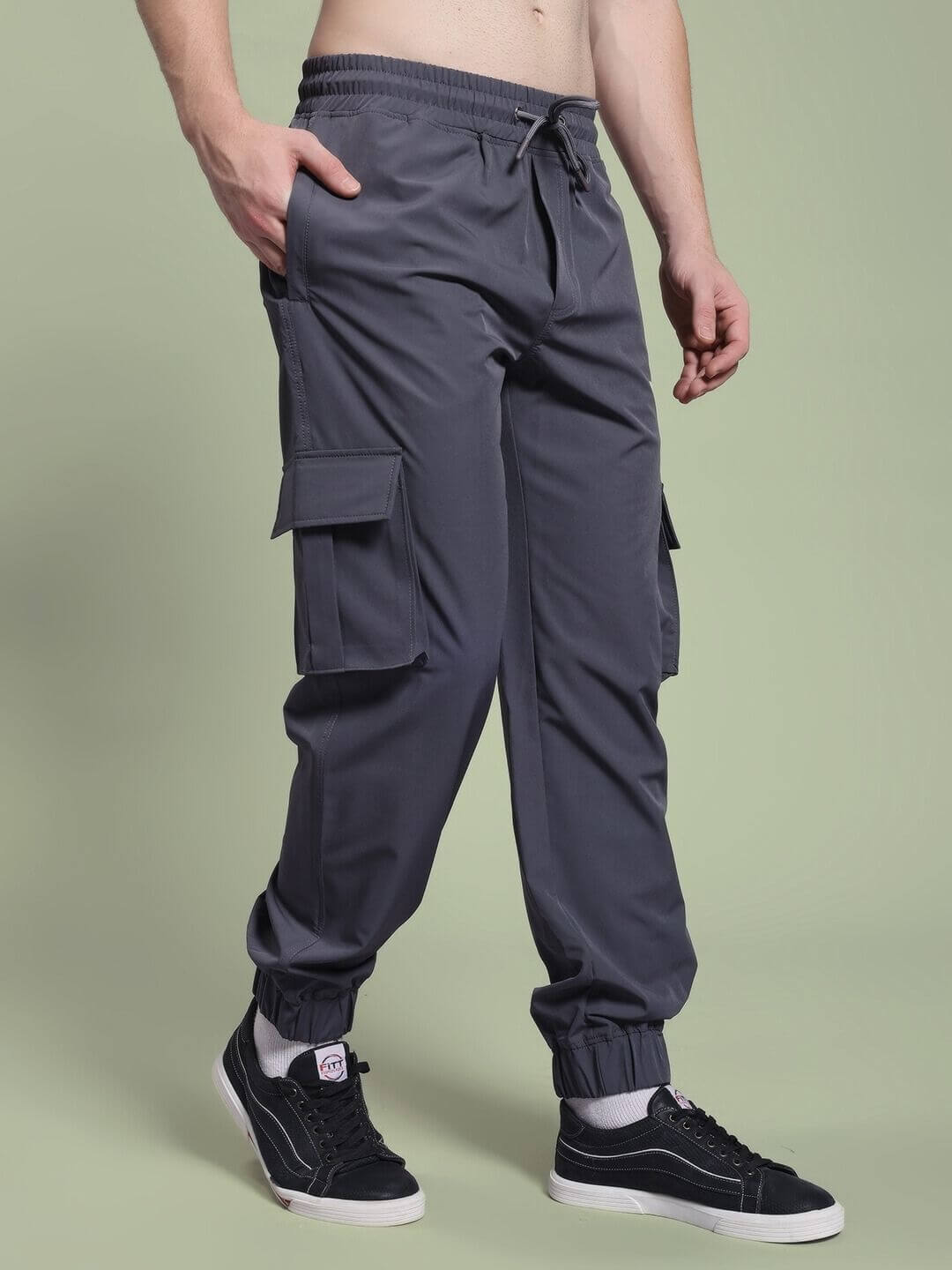 Model wearing JACK RELAXED FIT MULTI POCKET CARGO DARK GREY pants with sneakers, showcasing utility style and comfort.