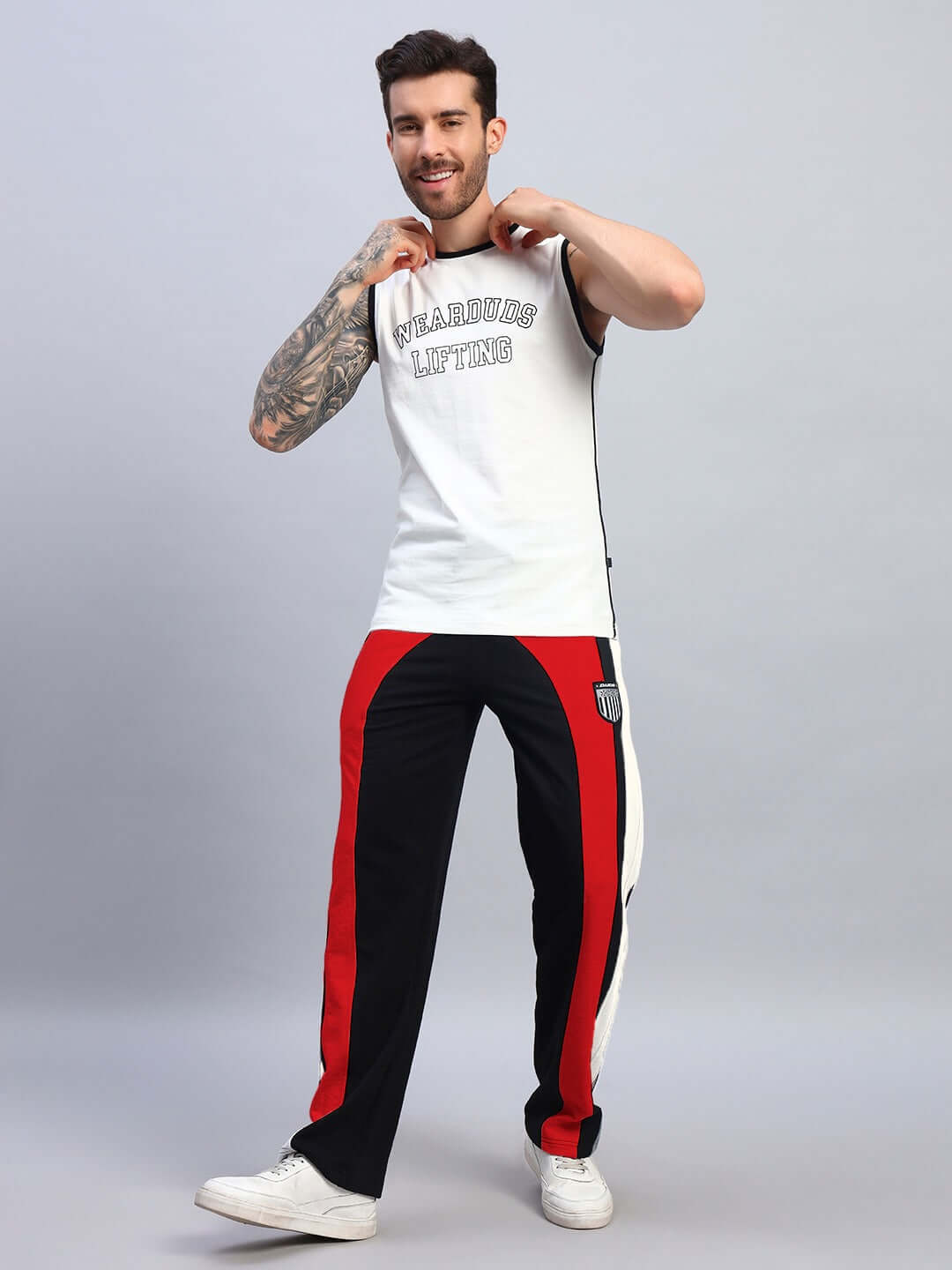 Man wearing JAMISON COLOR BLOCK RELAXED-FIT JOGGERS BLACK RED with white sneakers, posing with a casual and stylish look.