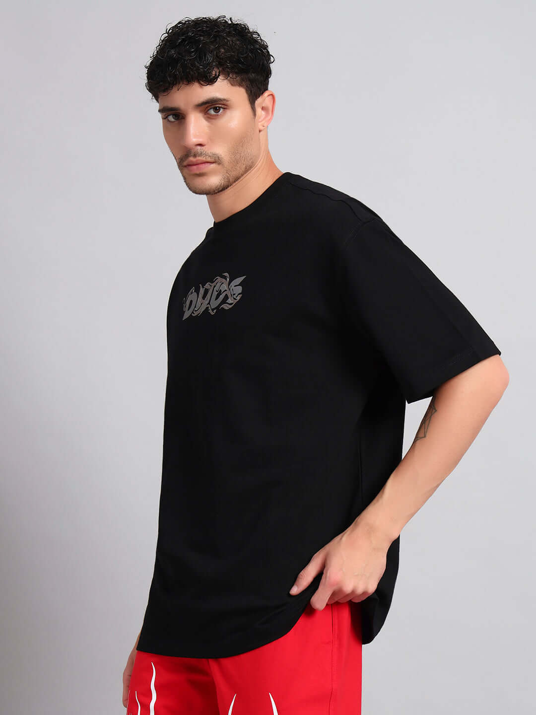 Man wearing JELVIN OVER-SIZED T-SHIRT BLACK showcasing streetwear fashion style.