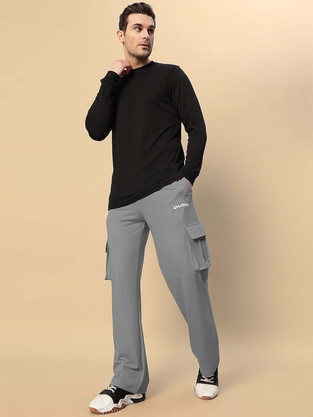 Model wearing grey JESS 5 pocket relaxed fit joggers by DUDS, showcasing side cargo pockets and comfortable fit for men.