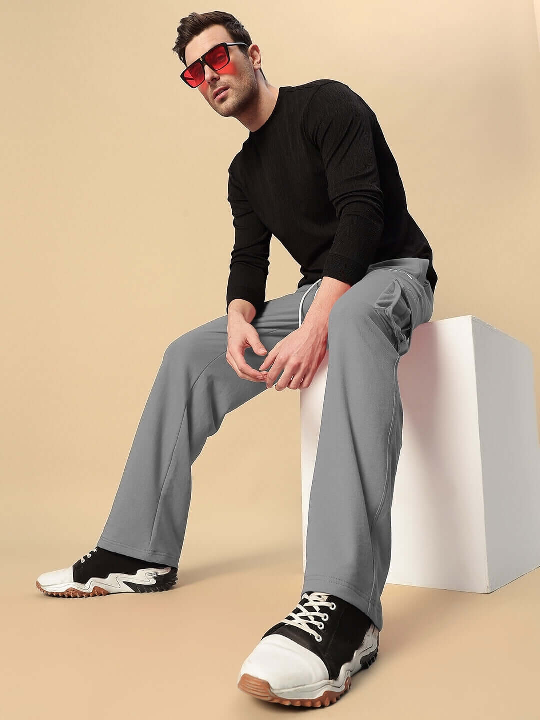 Model wearing JESS 5 Pocket Relaxed Fit Joggers in grey, sitting stylishly, highlighting the casual and comfortable design by DUDS.