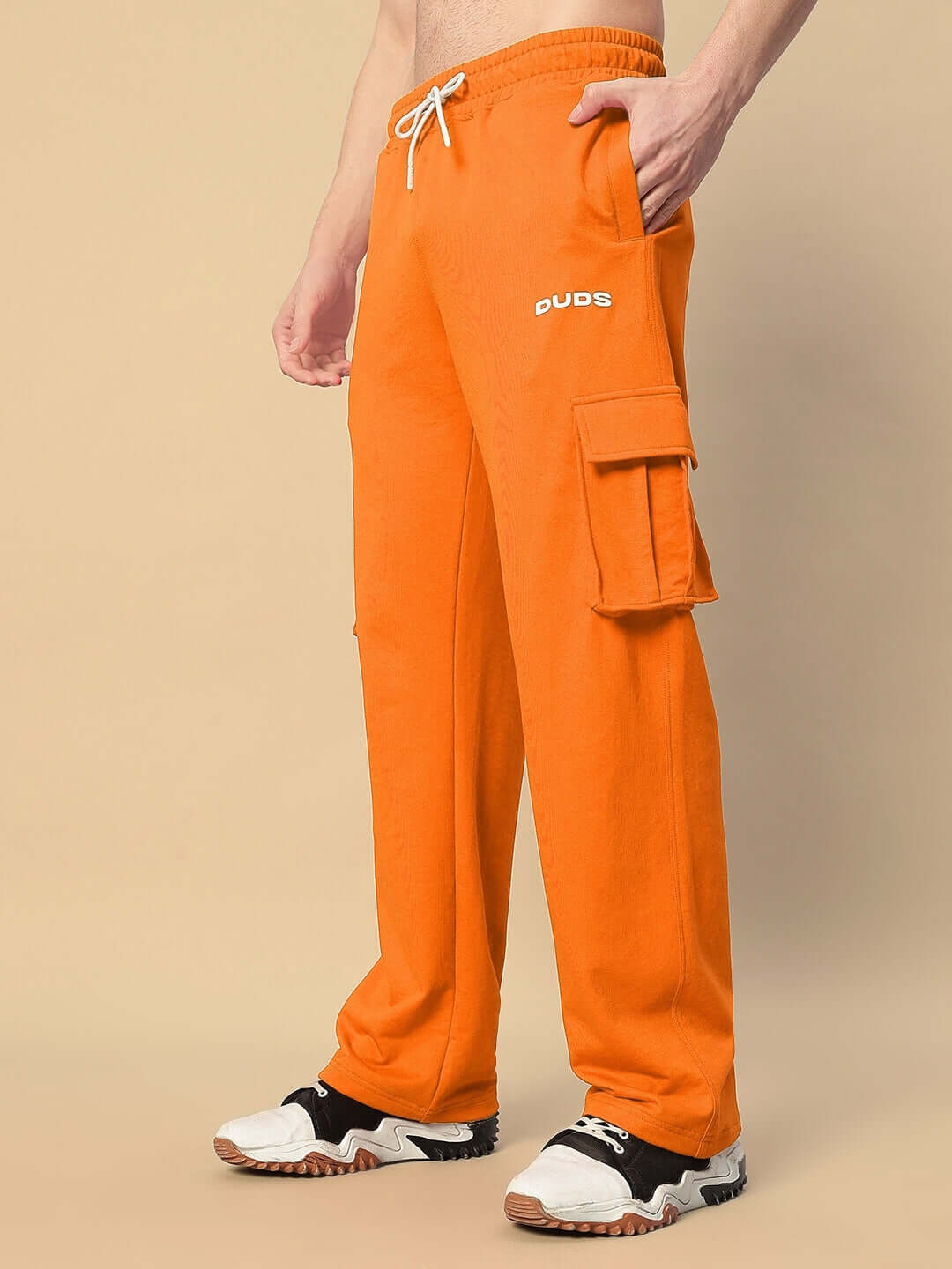 Model wearing JESS 5 Pocket Relaxed Fit Joggers in orange by DUDS, showcasing cargo pockets and comfortable design.
