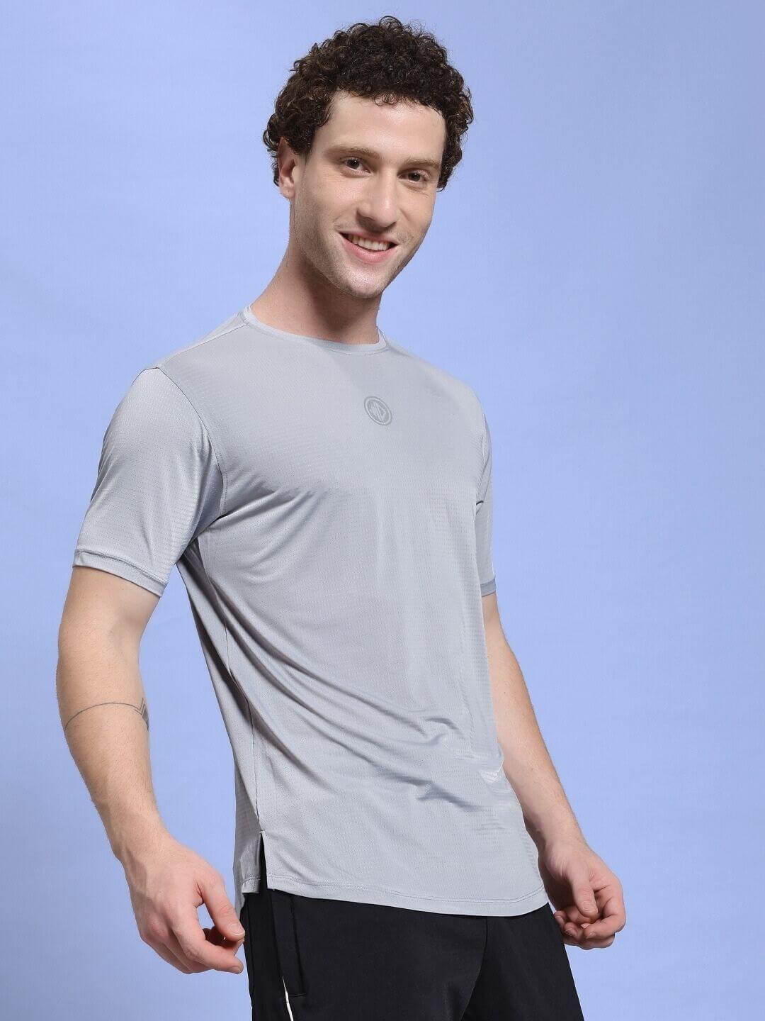 Man wearing JET RUN REGULAR FIT T-SHIRT GREY against a blue background.