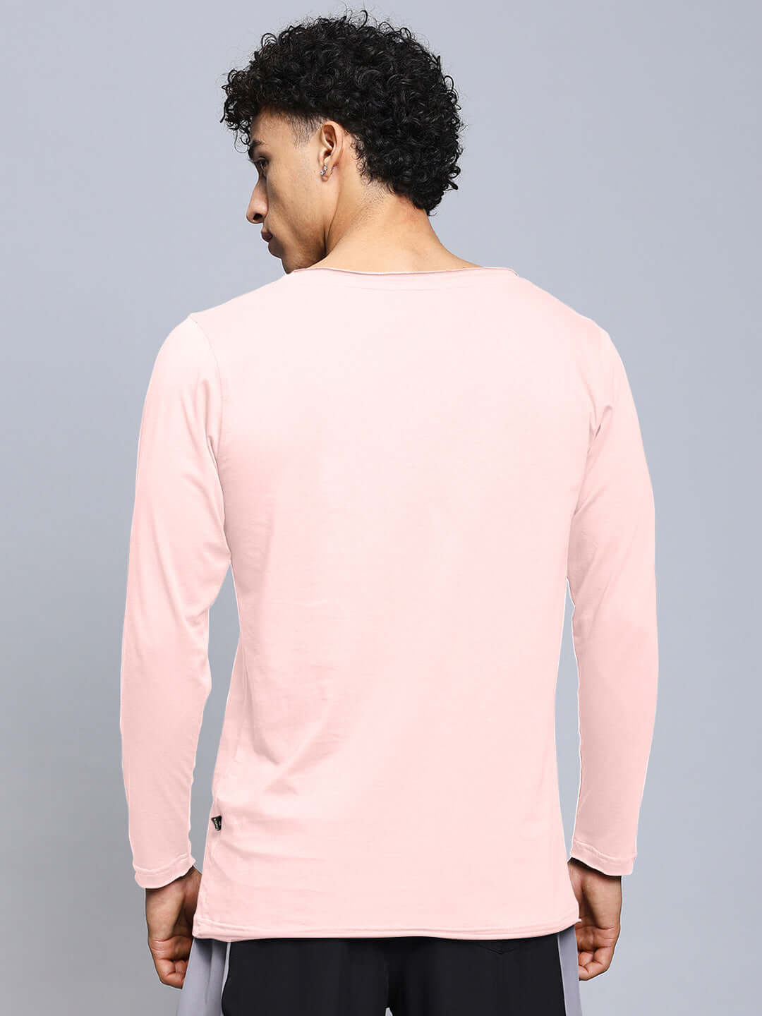 Back view of a man wearing a JOEL slim fit sweatshirt in baby pink, made of 100% cotton. Premium quality from Color By Colours, India.