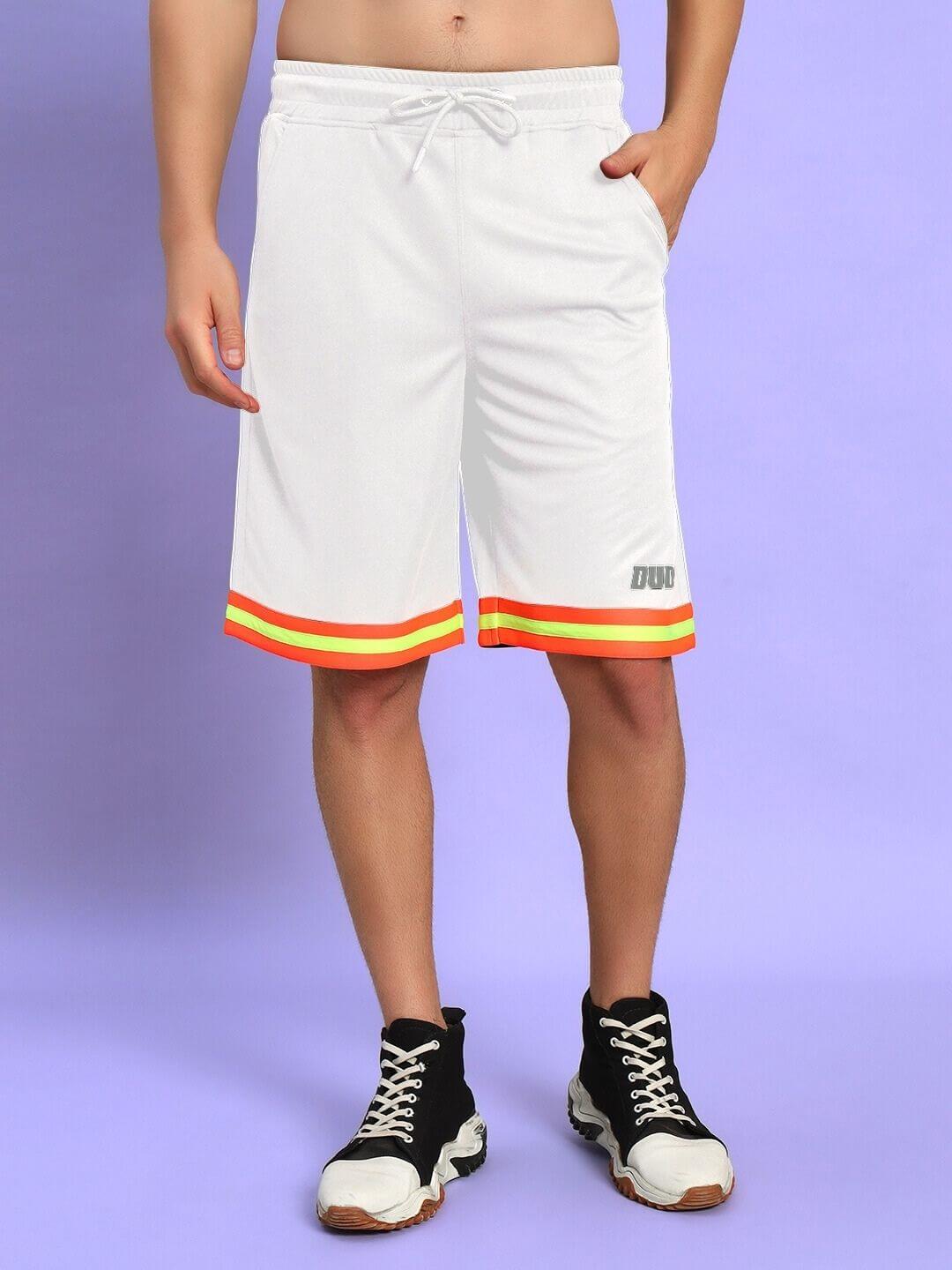 Person wearing JORDAN GYM REGULAR FIT CO-ORD SET WHITE with colorful trim on shorts, standing against a purple background.