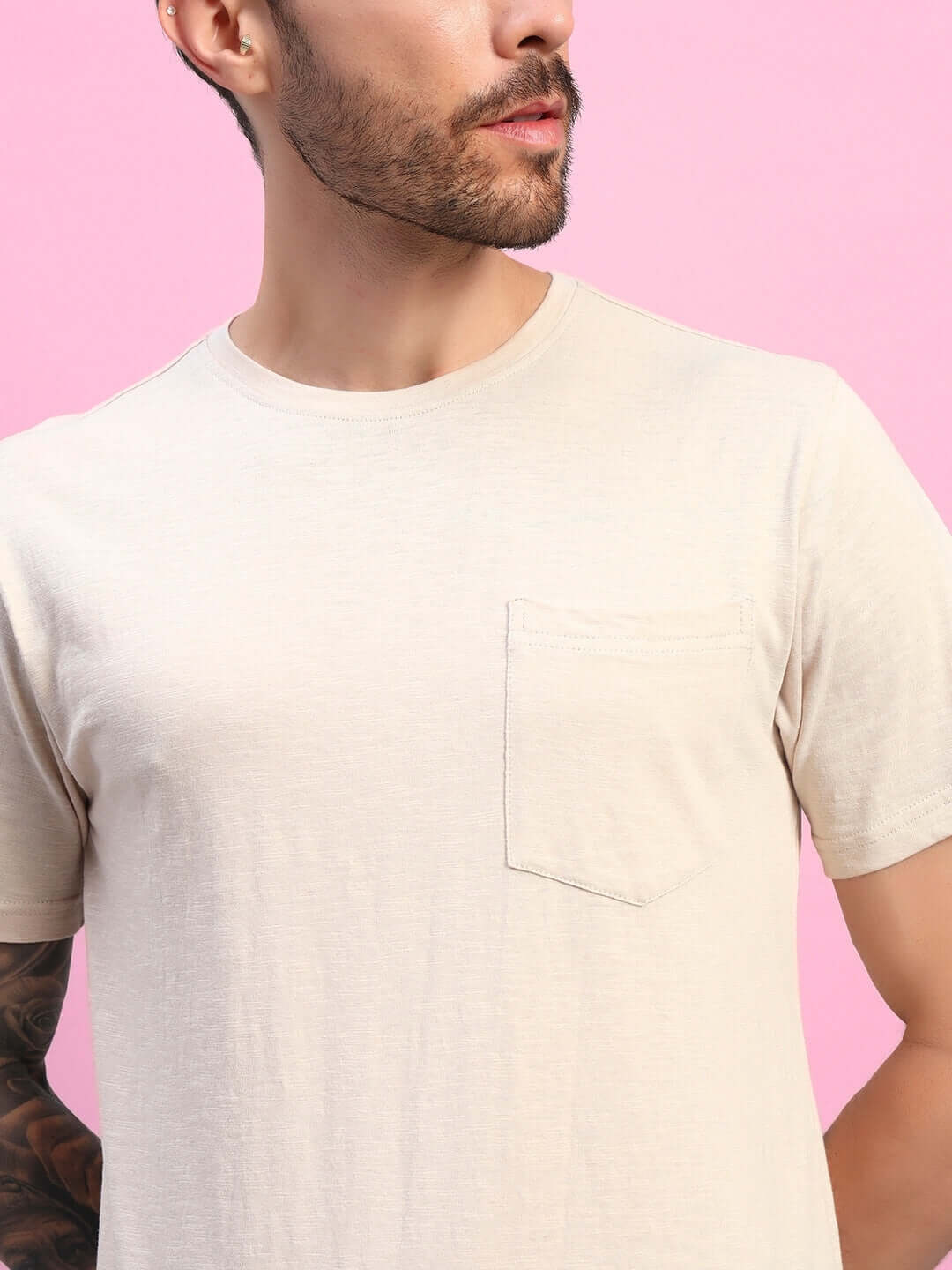 Model wearing JOY Regular Fit T-Shirt in Beige, made from premium 100% cotton slub fabric, showcased against a pink background.
