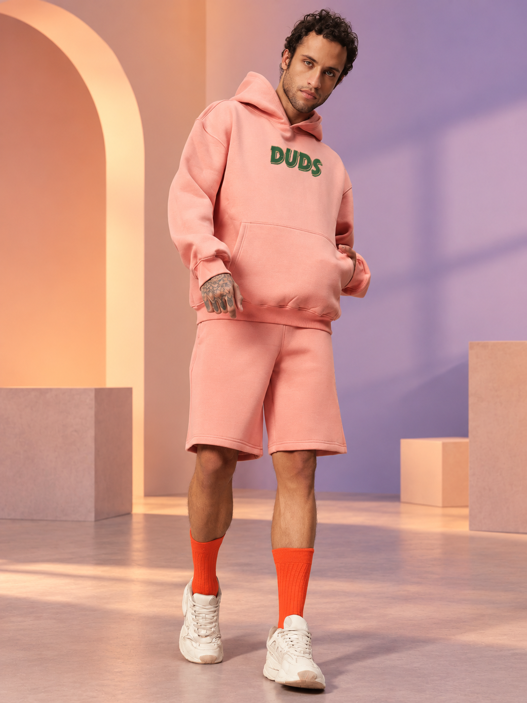 Man wearing JUDY NICK ZOOTOPIA FLEECE CO-ORD PEACH hoodie and shorts set, unisex streetwear comfort outfit