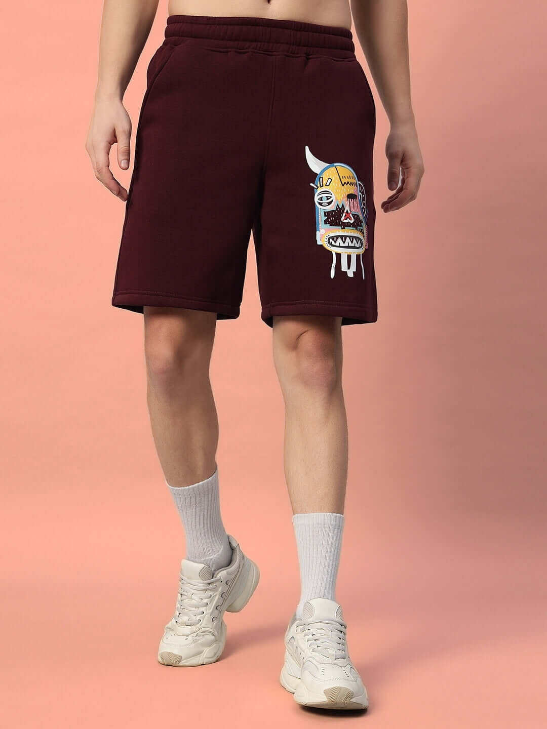 Model wearing WEARDUDS JUMBLED FLEECE SHORTS WINE with an abstract design on leg.