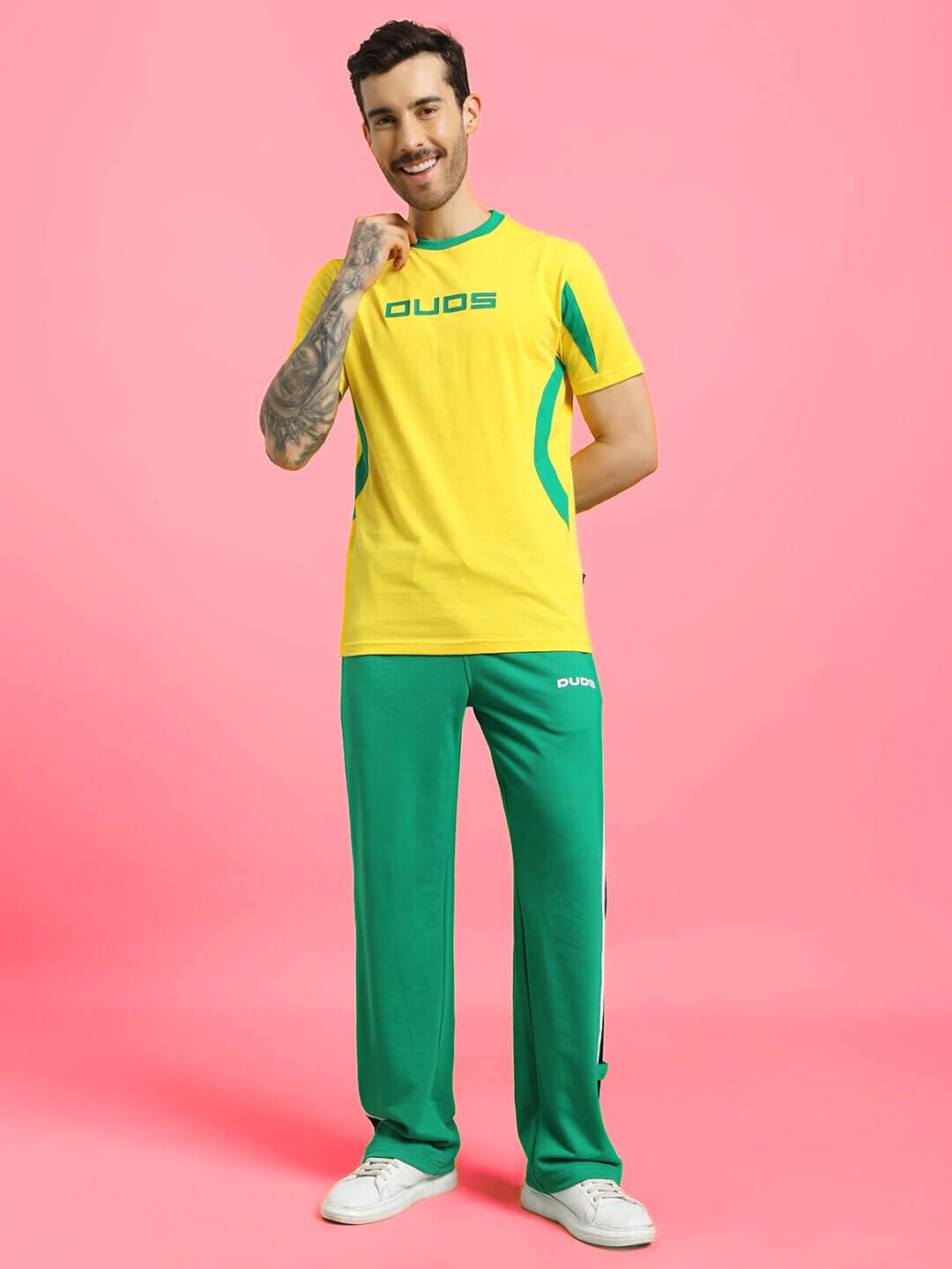Man wearing JUMPY REGULAR FIT T-SHIRT YELLOW with green pants standing on a pink background