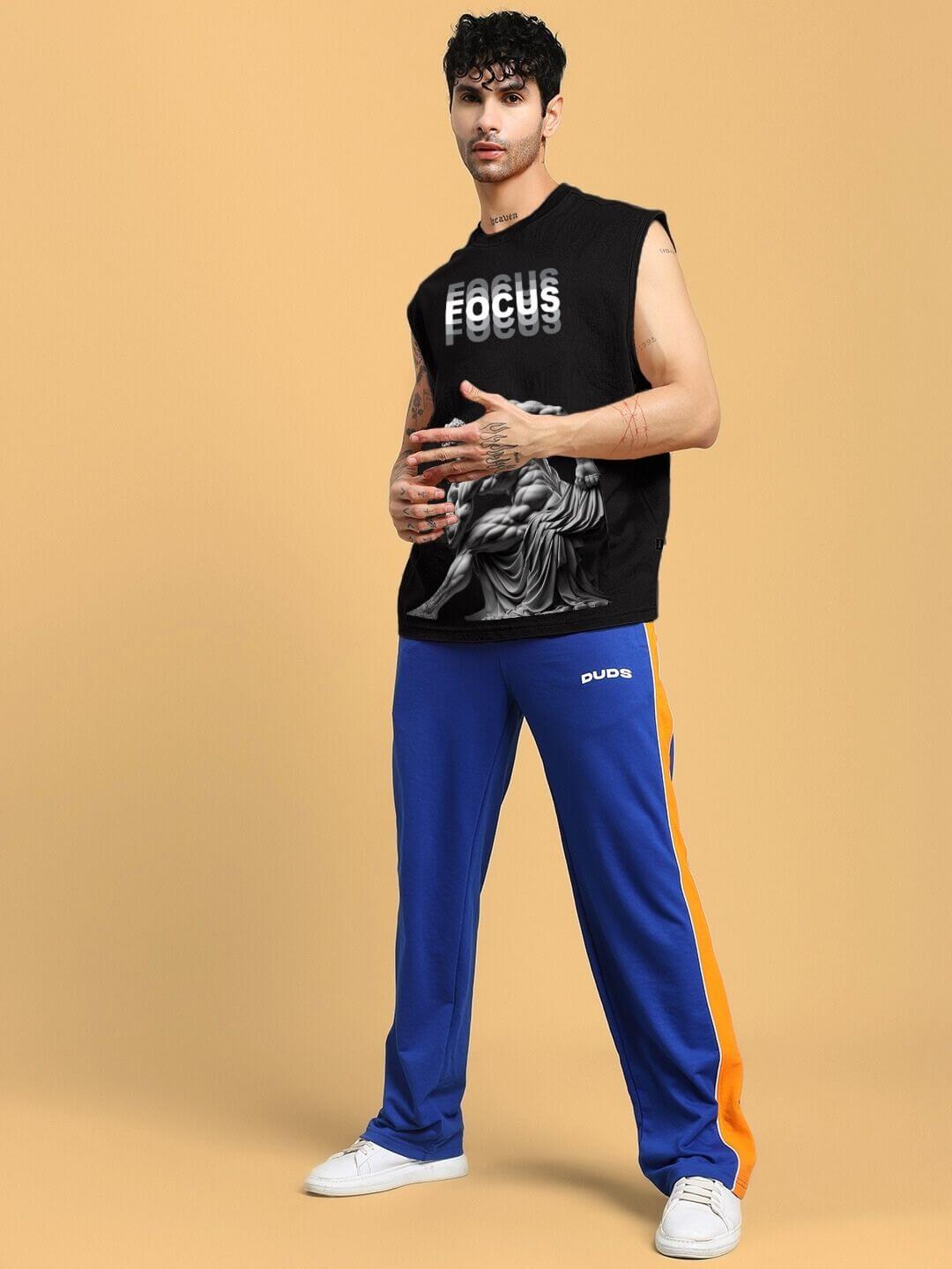 Model wearing JUST FOCUS black fine t-shirt with custom fit option, shown with blue and orange pants by DUDS.