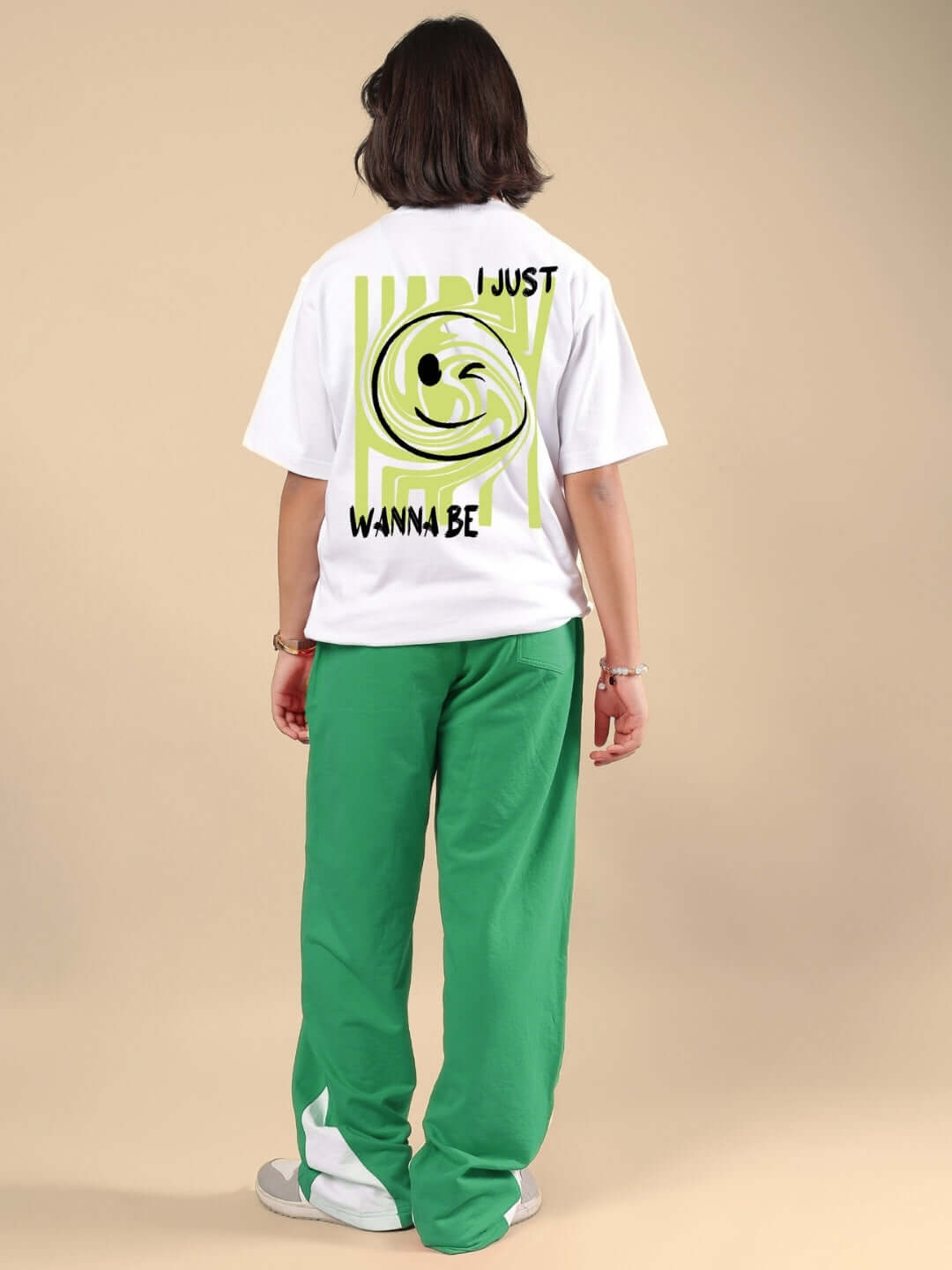 Person wearing JUST WANNA BE CO-ORD FOR BOYS & GIRLS WHITE-GREEN outfit, featuring a white t-shirt with graphic and green pants.