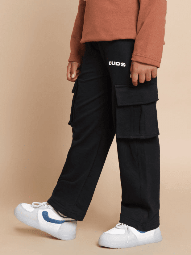 Child wearing KEEP FLYING CO-ORD FOR BOYS GIRLS BROWN BLACK set with brown top and black joggers