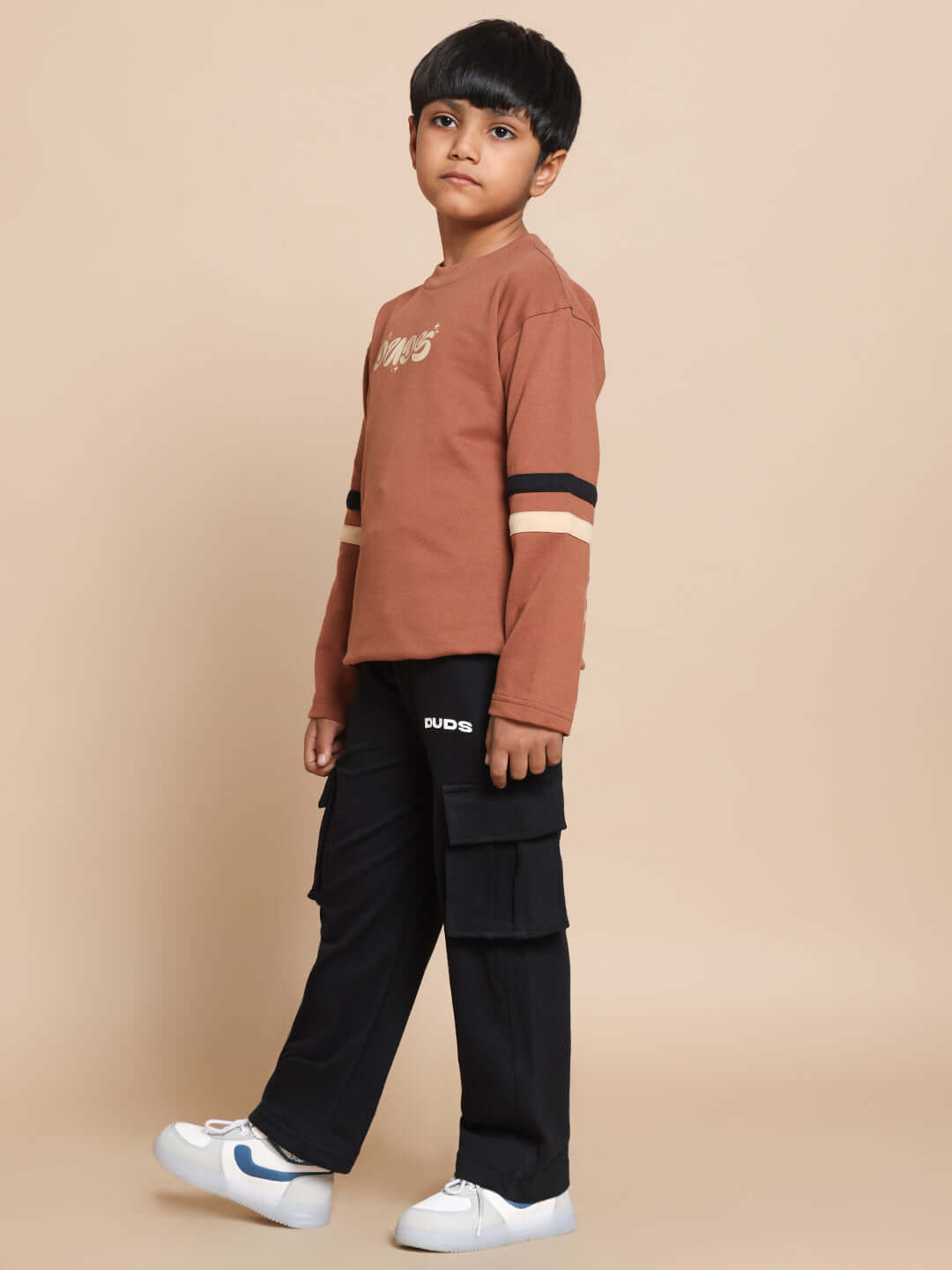Child wearing KEEP FLYING brown-black co-ord set by DUDS, featuring made-to-order outfit with customizable fit options.