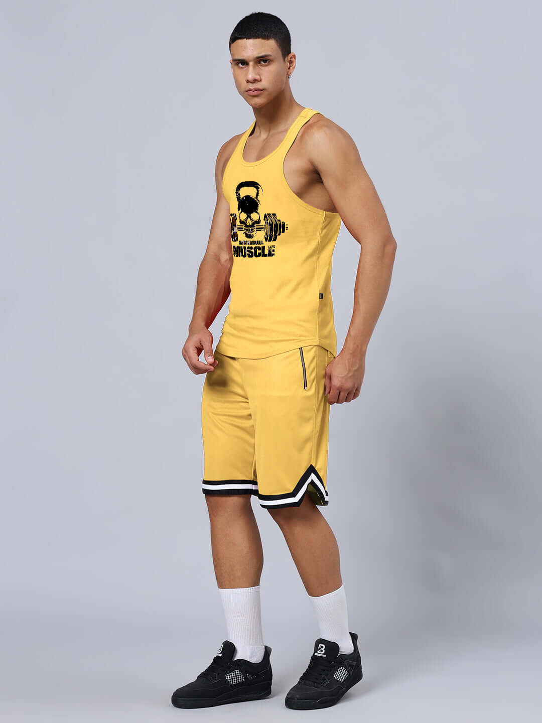 Man wearing KETTLEBELL SKULL PRINTED GYM CO-ORD SET YELLOW, featuring a sleeveless top and shorts, ideal for workout sessions.