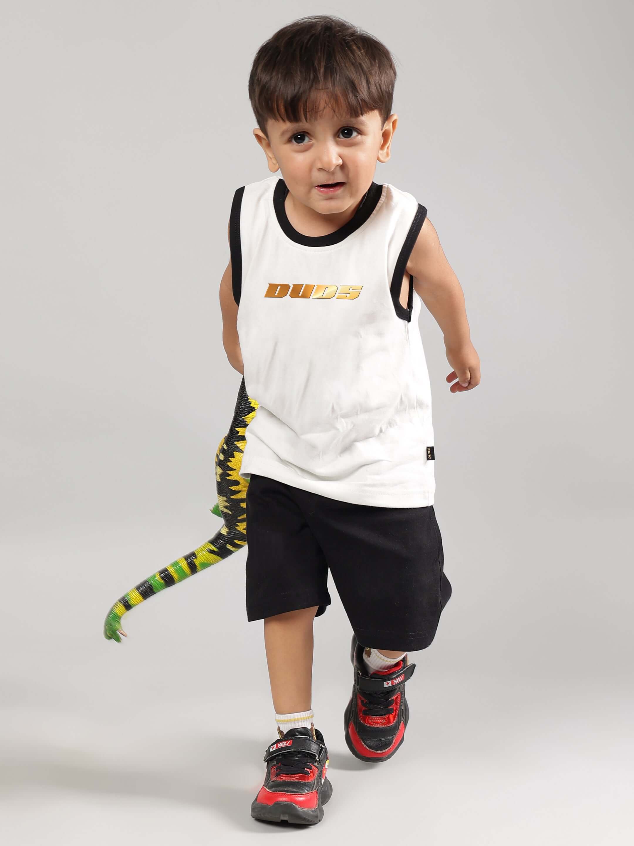 Boy wearing KEVIN summer co-ord in off white and black with a stylish design from DUDS.