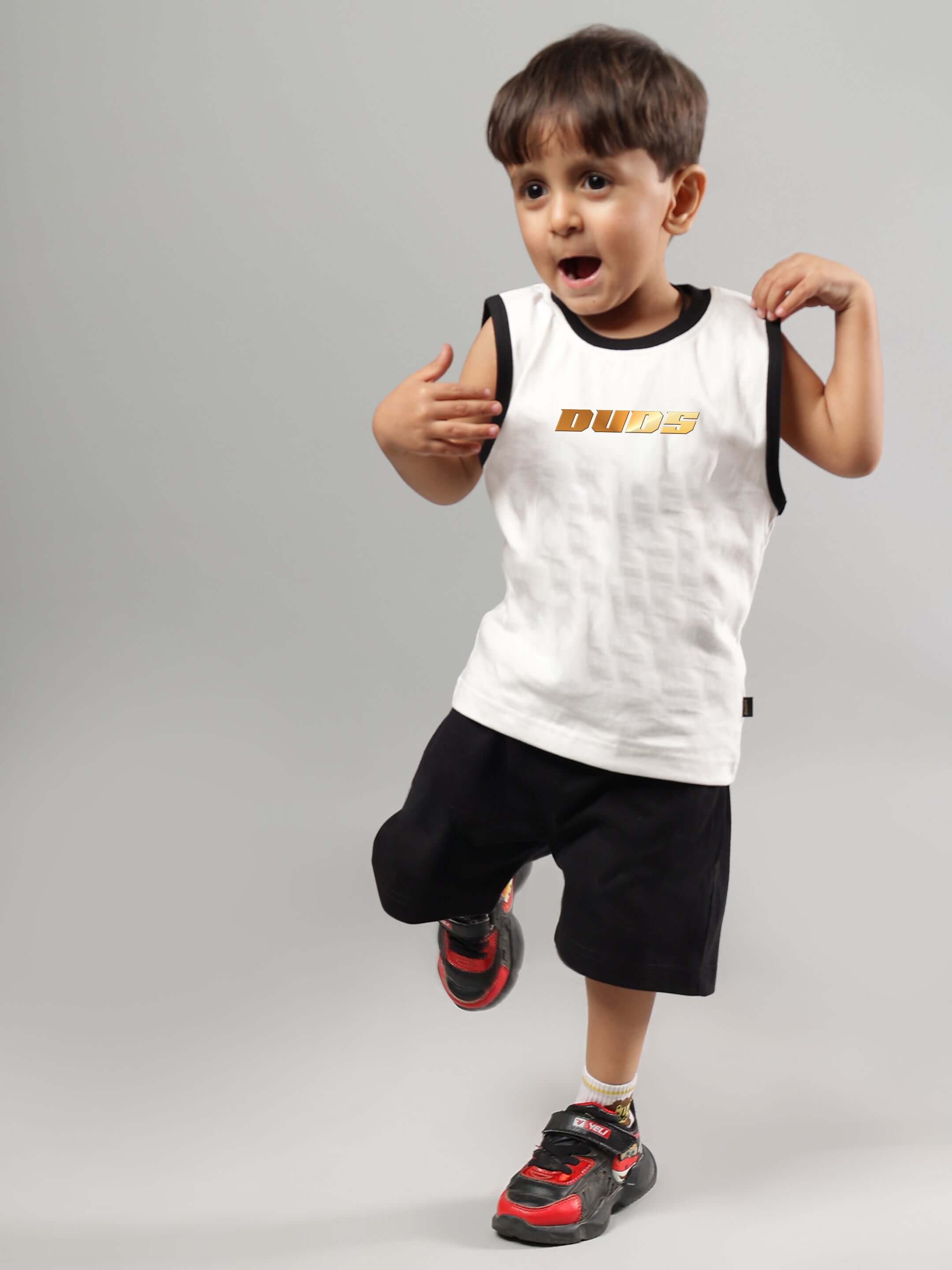 Young child wearing the KEVIN Summer Co-Ord in off white and black by DUDS, showcasing a stylish and comfortable outfit for boys and girls.
