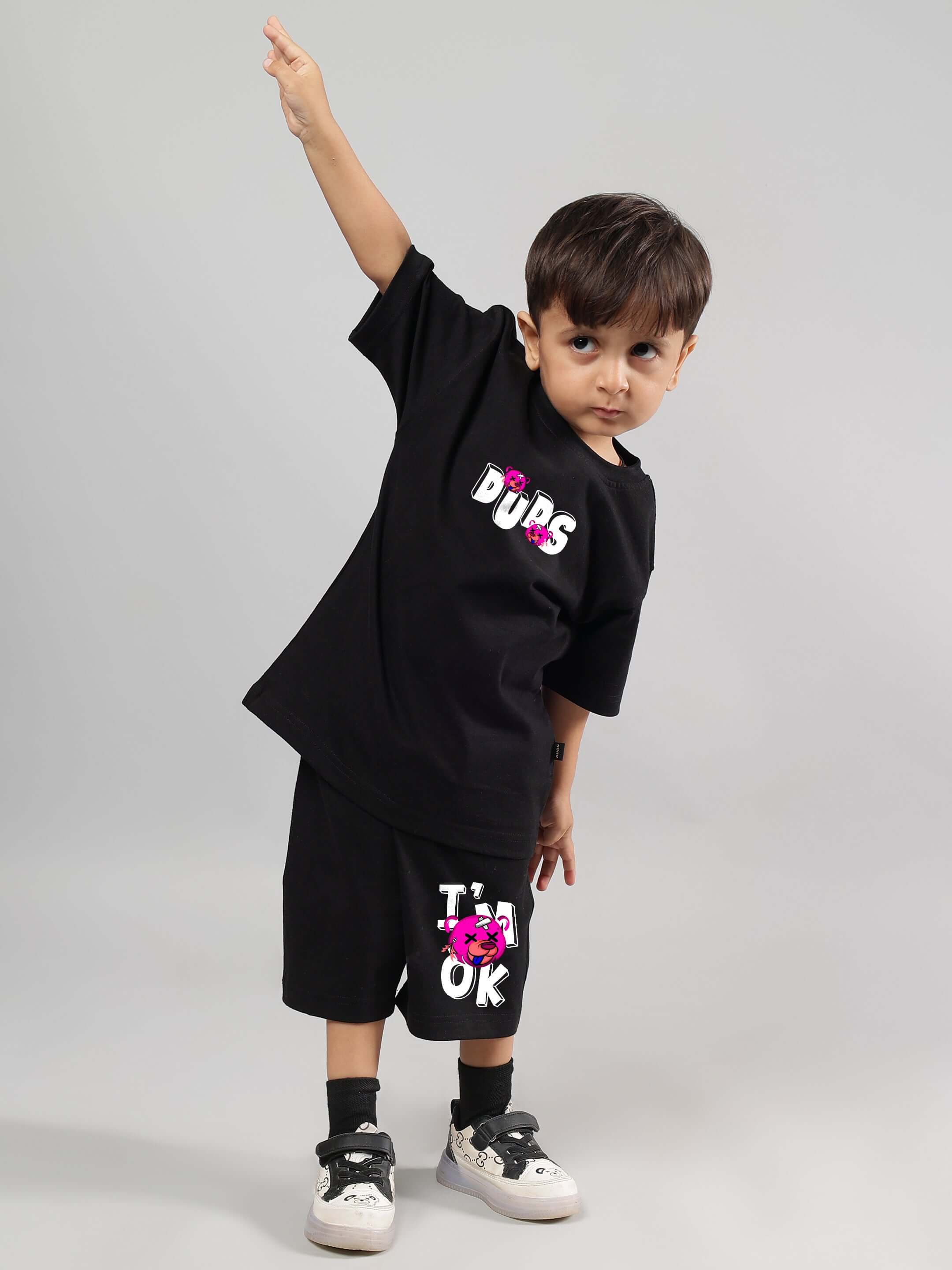 Child wearing a black I'M OK co-ord set by DUDS, showcasing playful style and comfort for boys and girls. Made to order with custom fit option.