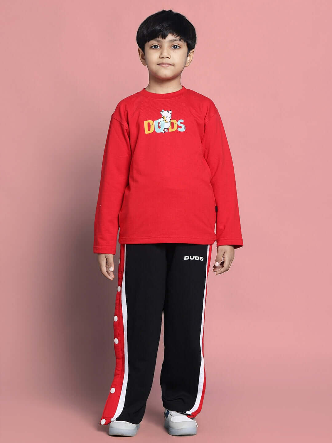 Child wearing red DUDS Winnie Co-ord set, featuring red top and black pants with red side stripes, suitable for boys and girls.