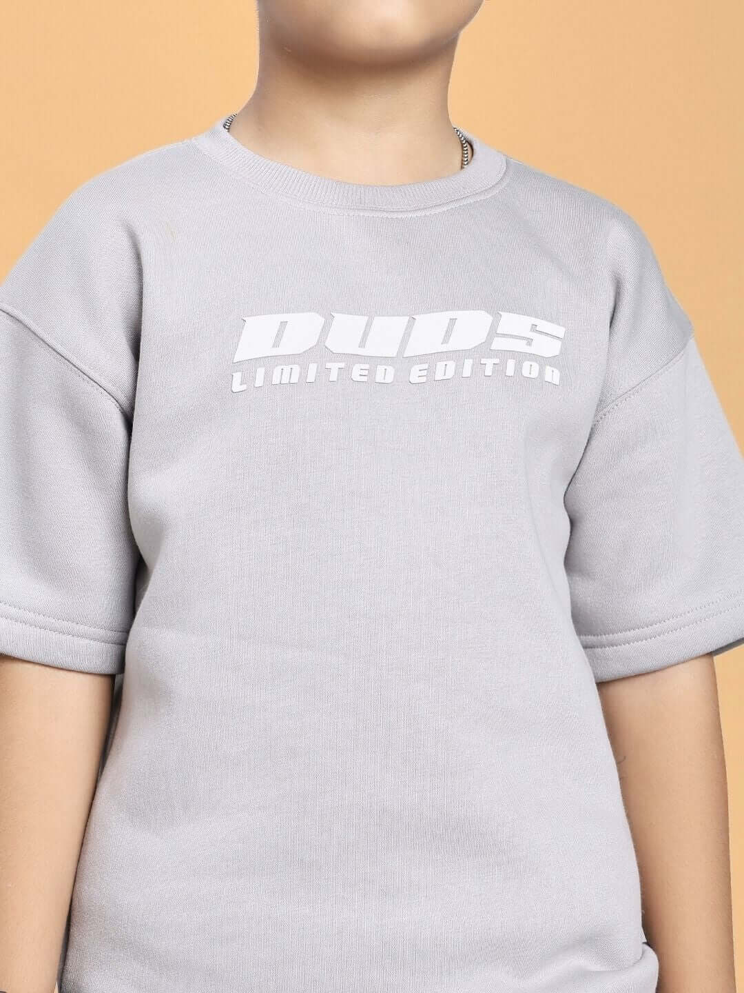 Young model wearing SKODA FLEECE T-SHIRT FOR BOYS AND GIRLS GREY with "Duds Limited Edition" print.