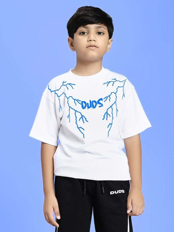 Boy wearing a white t-shirt with blue graphic design on a light blue background.