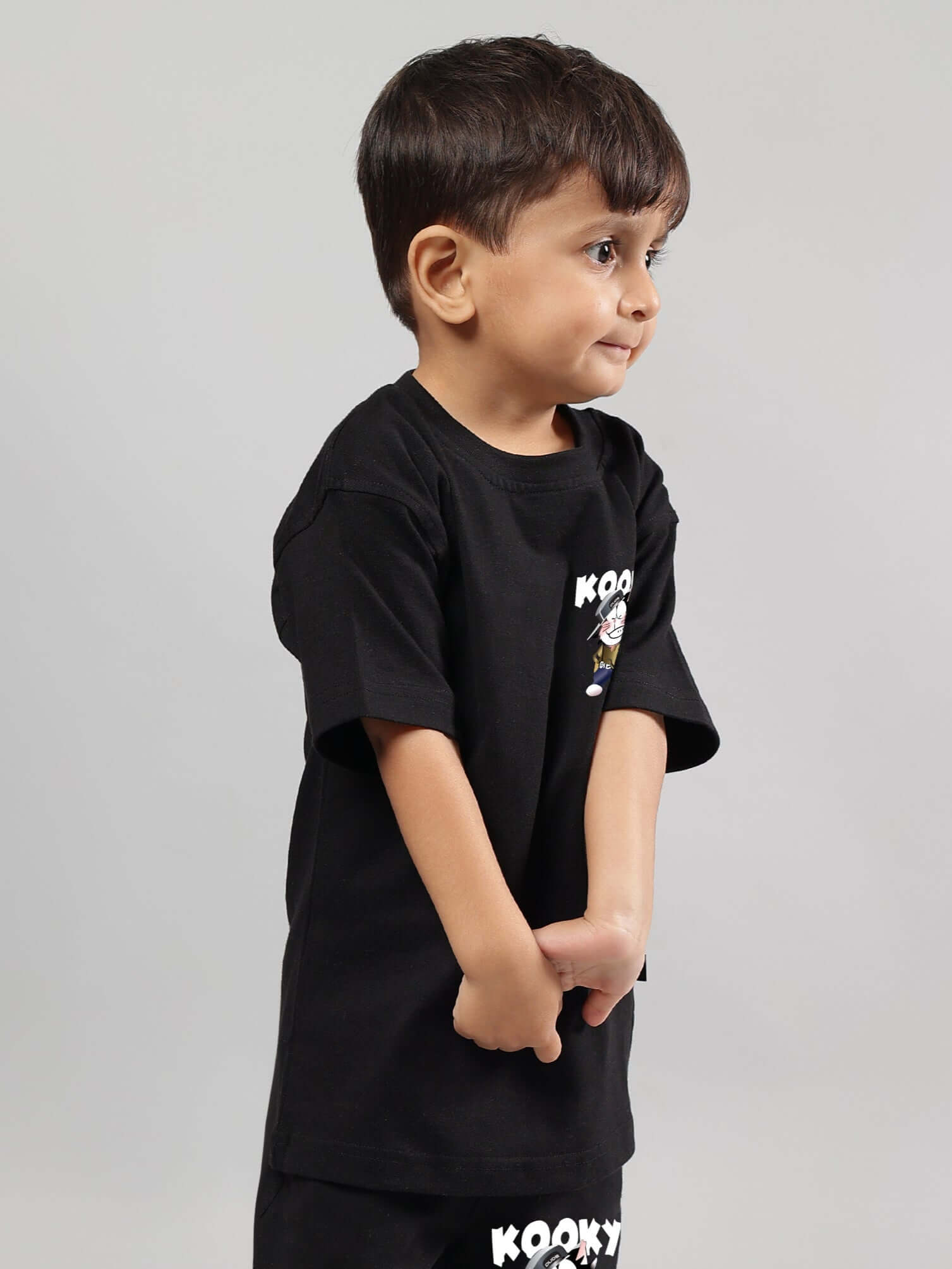 Young boy wearing KOOKY black t-shirt, suitable for boys and girls, highlighting fun and playful style.