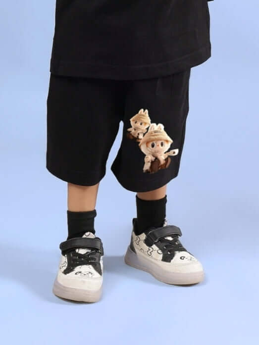 Child wearing LABUBU Gang black shorts with cartoon print, paired with black socks and sneakers. Suitable for boys and girls.