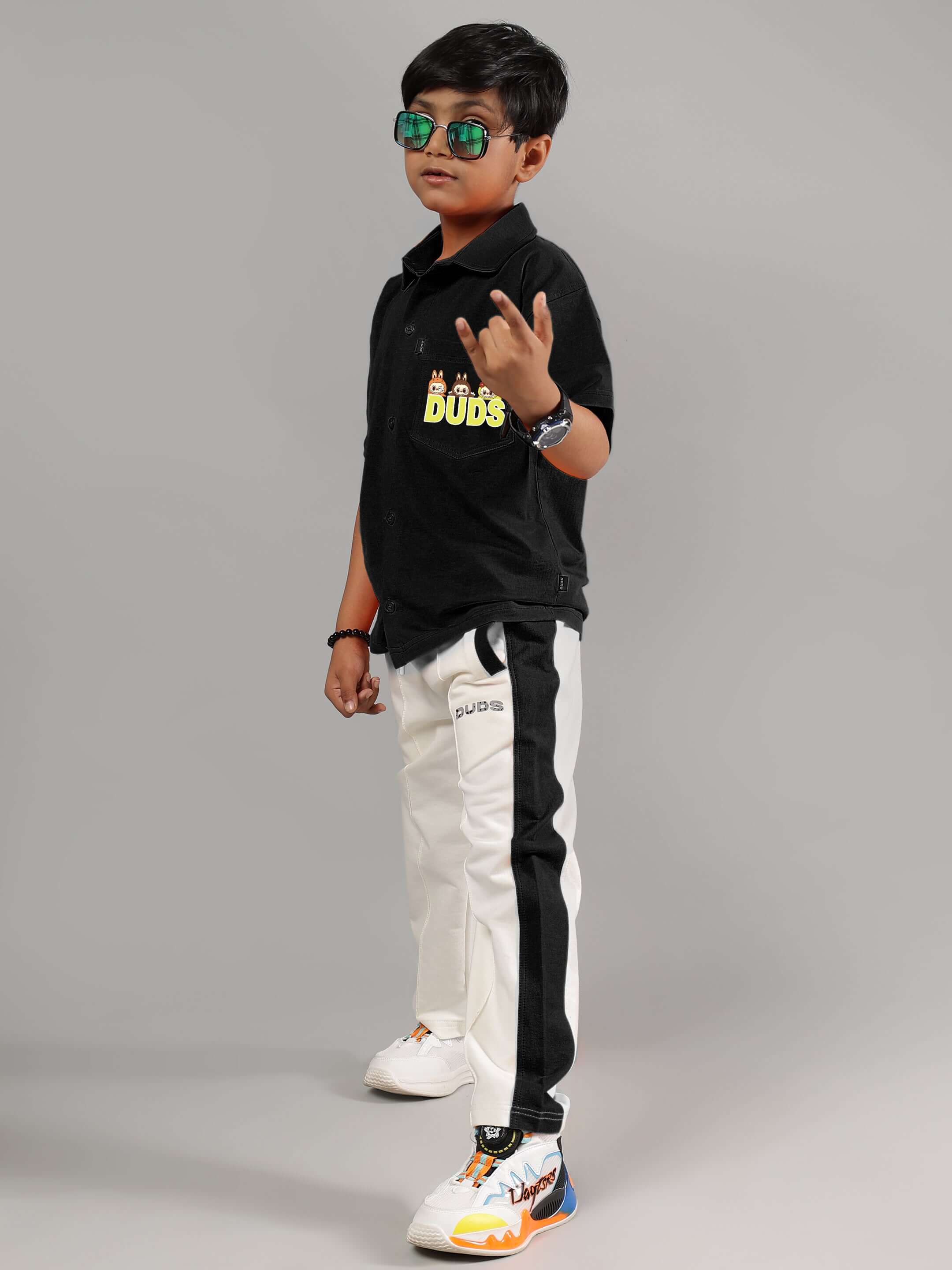 Child wearing black LABUBU Mystery Shirt by DUDS, paired with stylish pants and sneakers.