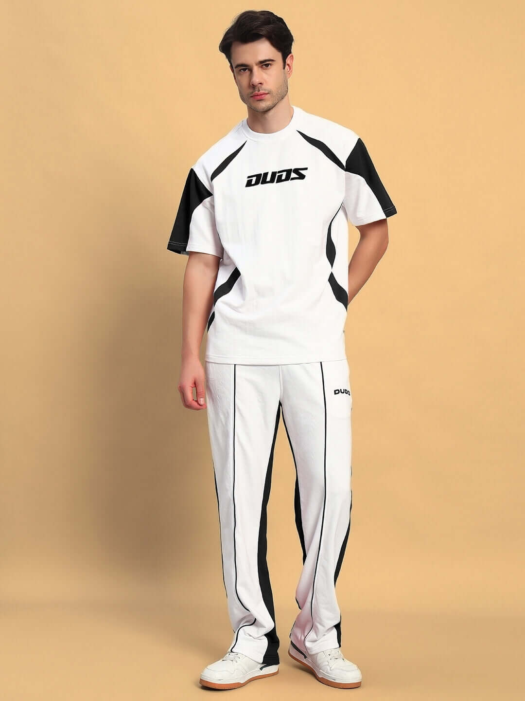 Model wearing LAGOON RELAXED FIT JOGGERS WHITE BLACK by DUDS shown on beige background