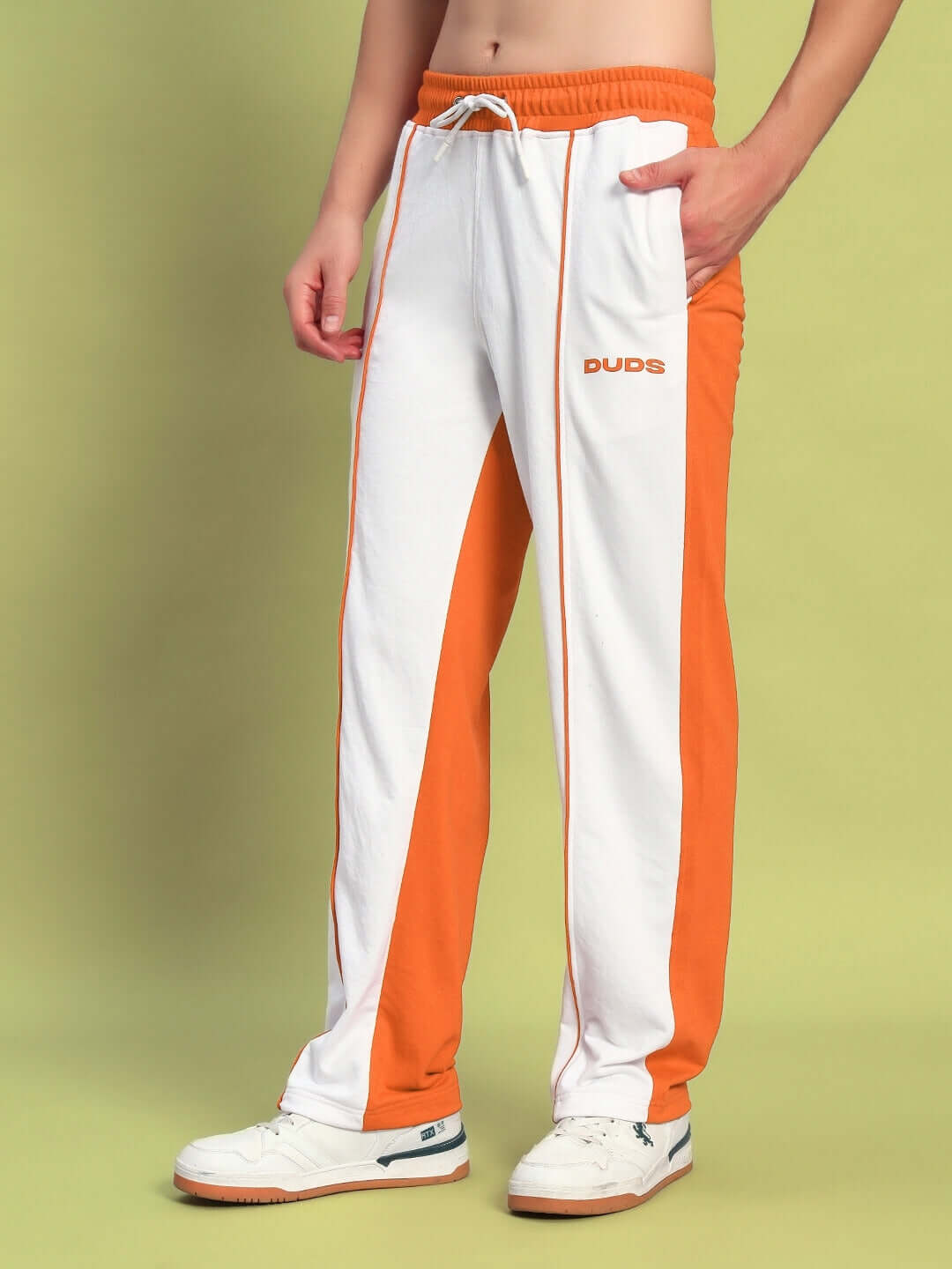 Man wearing Lagoon Relaxed Fit Joggers in white and orange with DUDS logo, showcasing casual style and comfort.