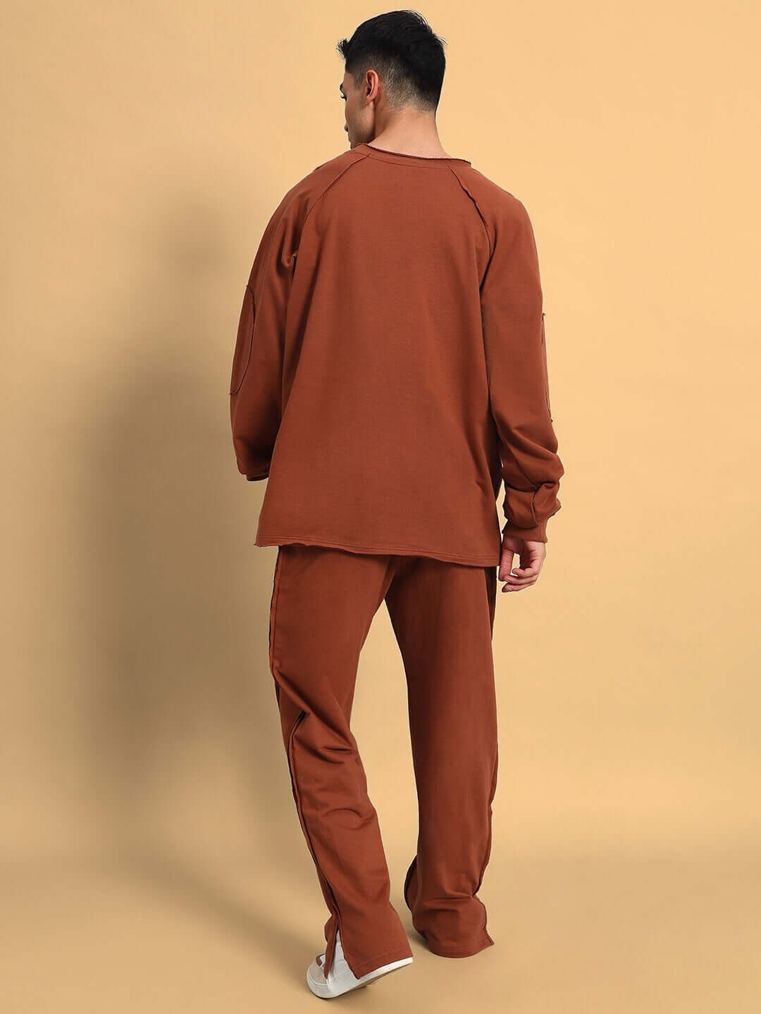 Back view of a model wearing brown Lamina Side Slit Joggers, showcasing custom fit and dedicated craftsmanship by DUDS.