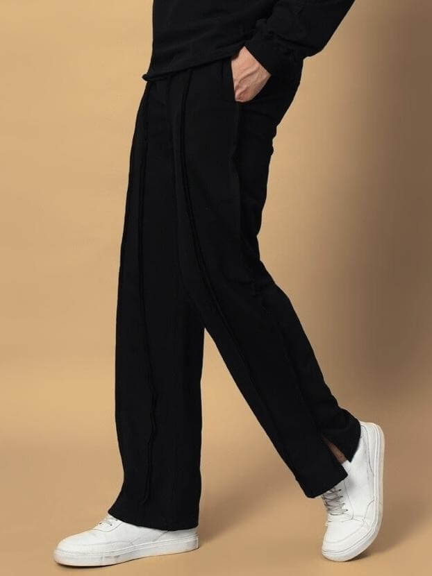 Black side slit joggers by LAMINA with a made-to-order design, showcased on a light background, paired with white sneakers.