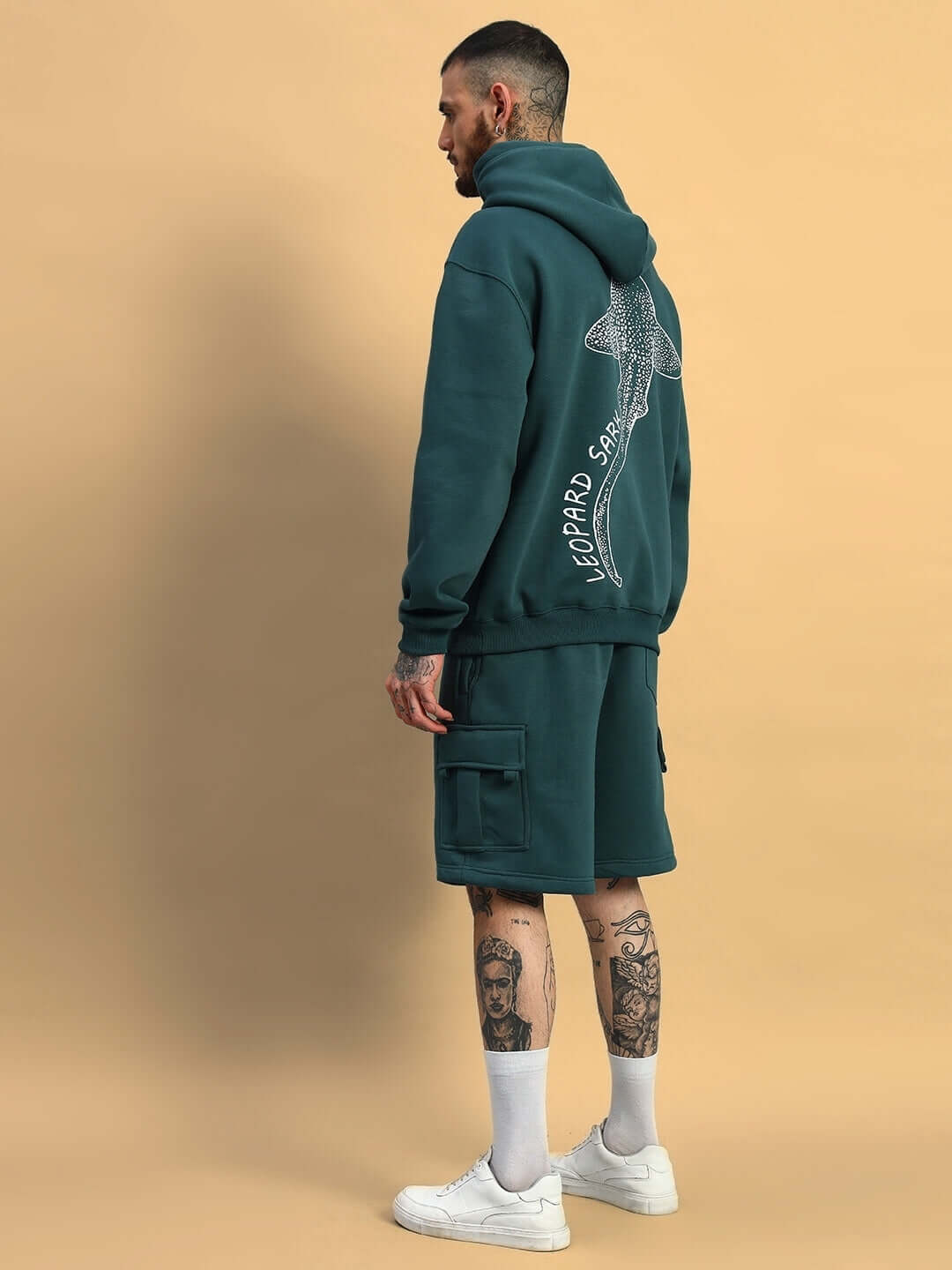 Man wearing LEOPARD SHARK FLEECE CO-ORD TEAL GREEN with back design, showcasing streetwear style.
