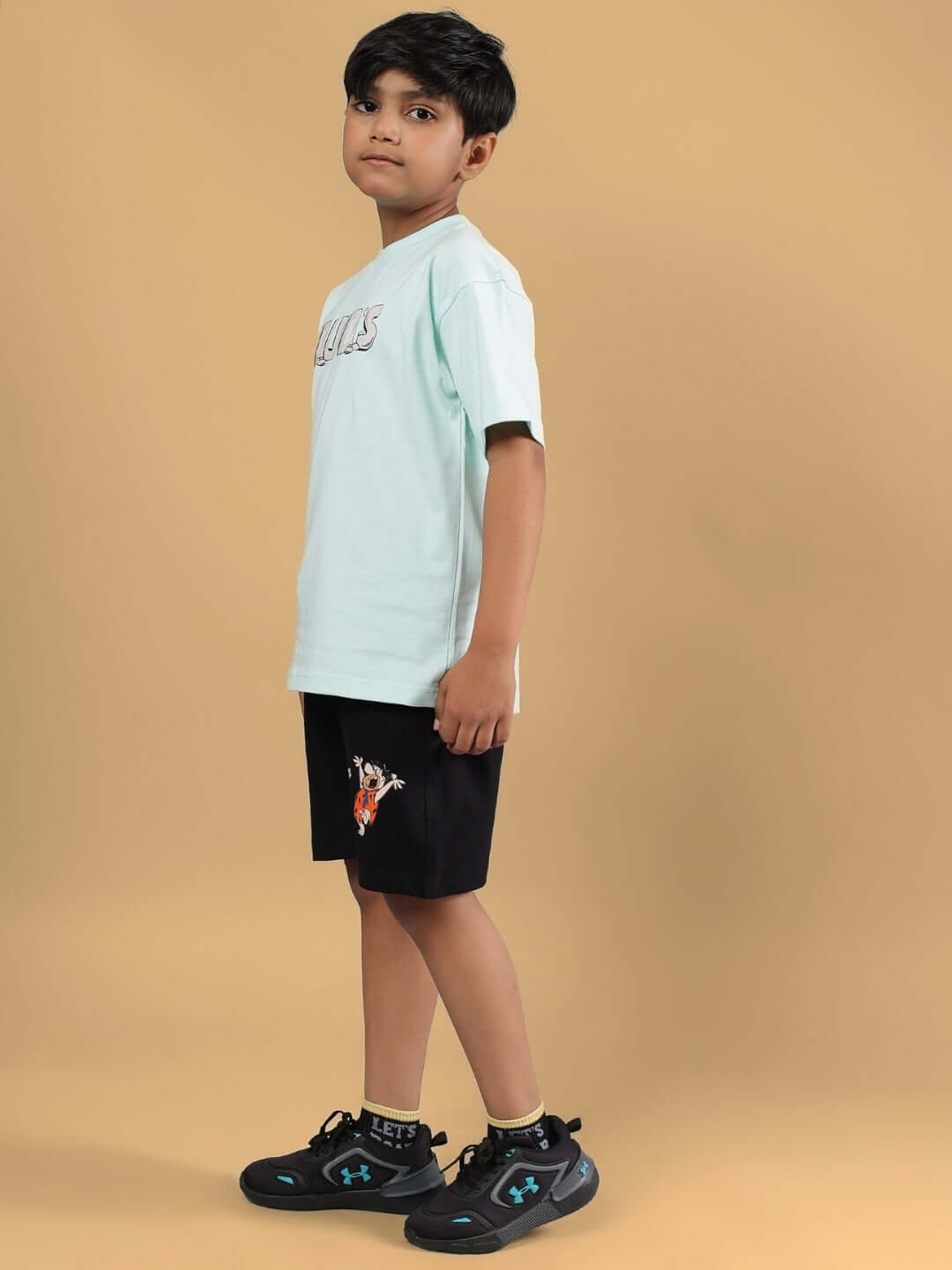 Boy wearing LET'S ROCK CO-ORD FOR BOYS & GIRLS S BLUE-BLACK, featuring a blue top and black shorts, side view, standing on a beige background.