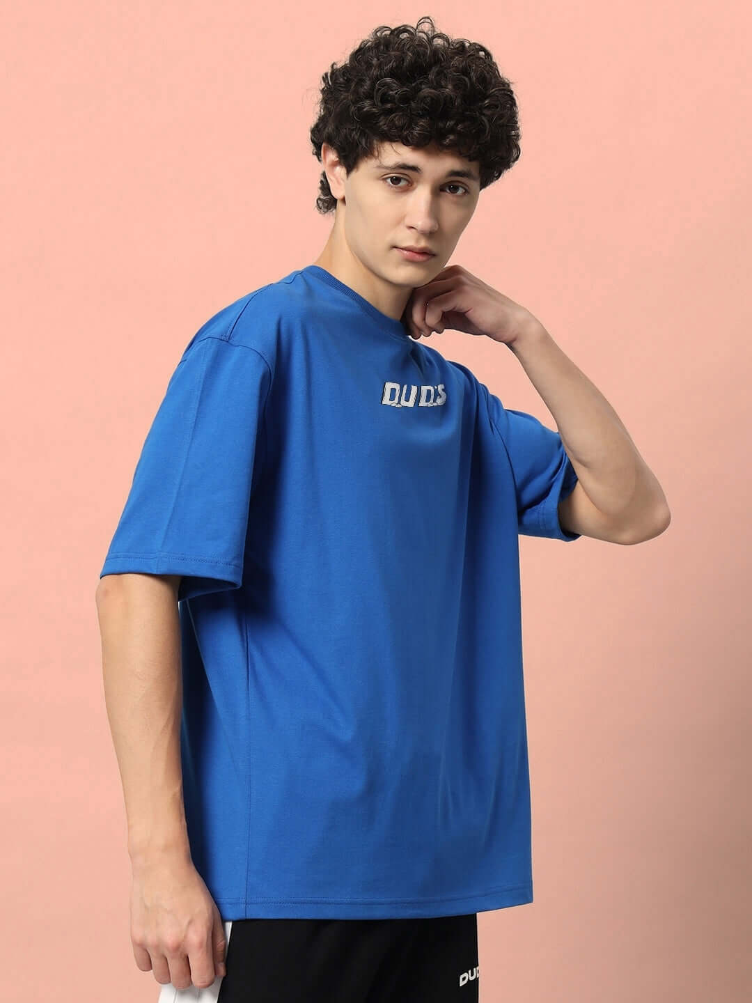 Man wearing LETS ROCK OVER-SIZED T-SHIRT ROYAL BLUE with relaxed graphic design, perfect for casual outings.