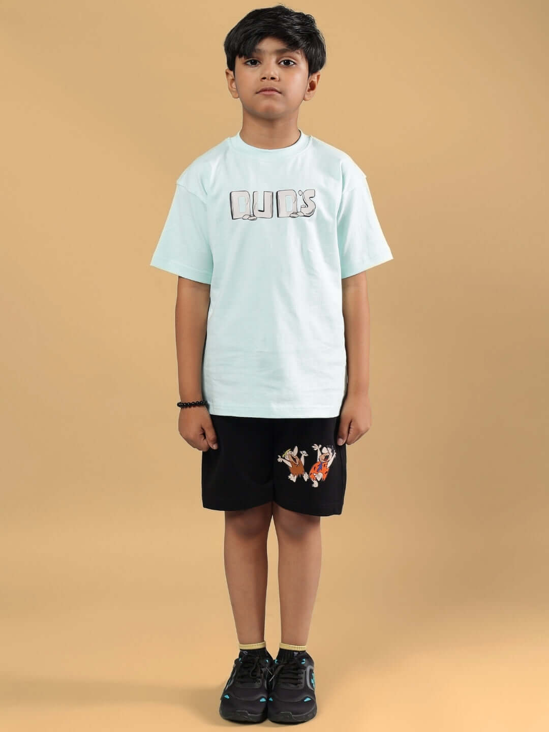 Child wearing LET'S ROCK SHORTS FOR BOYS & GIRLS BLACK with playful design, available for custom fit and made with care by DUDS.