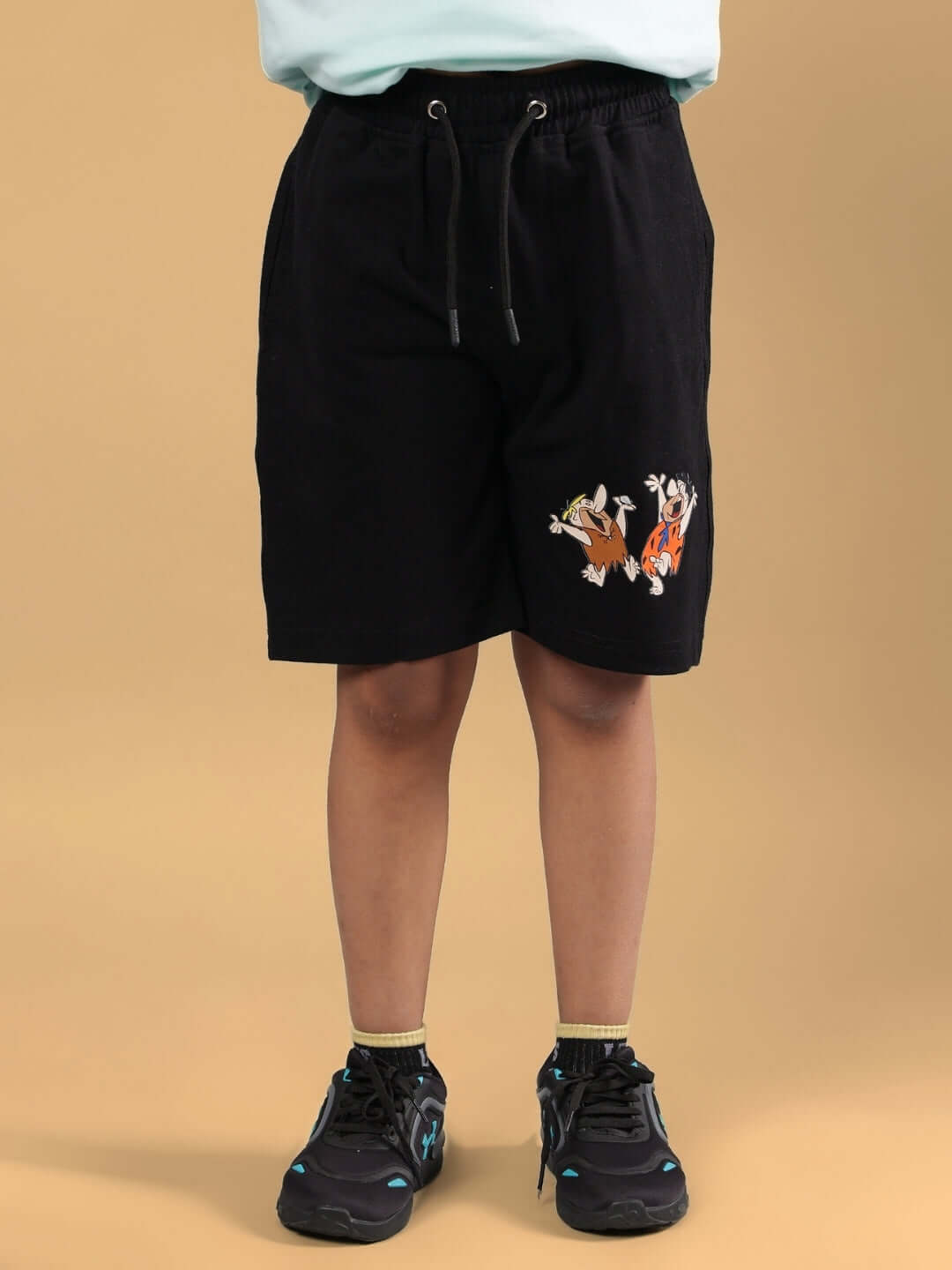 Child wearing LET'S ROCK SHORTS FOR BOYS & GIRLS BLACK with cartoon embroidery.