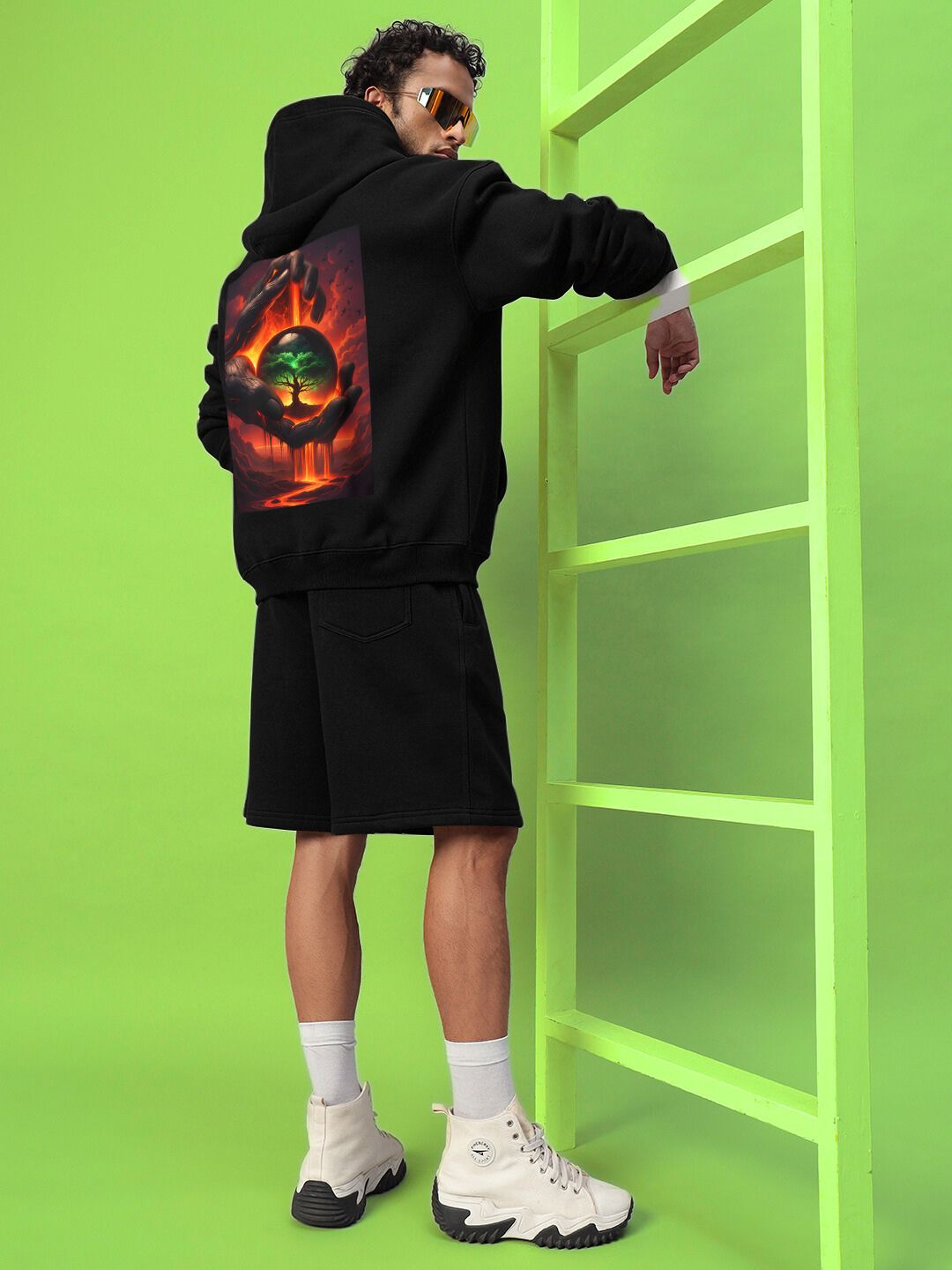 Model wearing LIFE IN THE CRUCIBLE PRINTED FLEECE HOODIE BLACK with bold graphic in a modern streetwear style