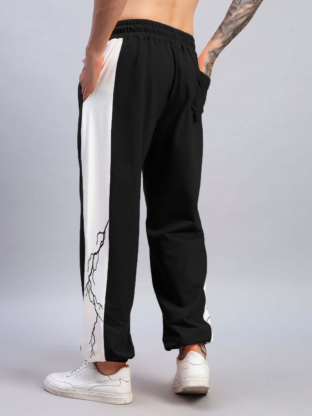 Person wearing LIGHTNING BOLT RELAXED FIT JOGGERS BLACK-WHITE, showcasing bold lightning design and relaxed silhouette.