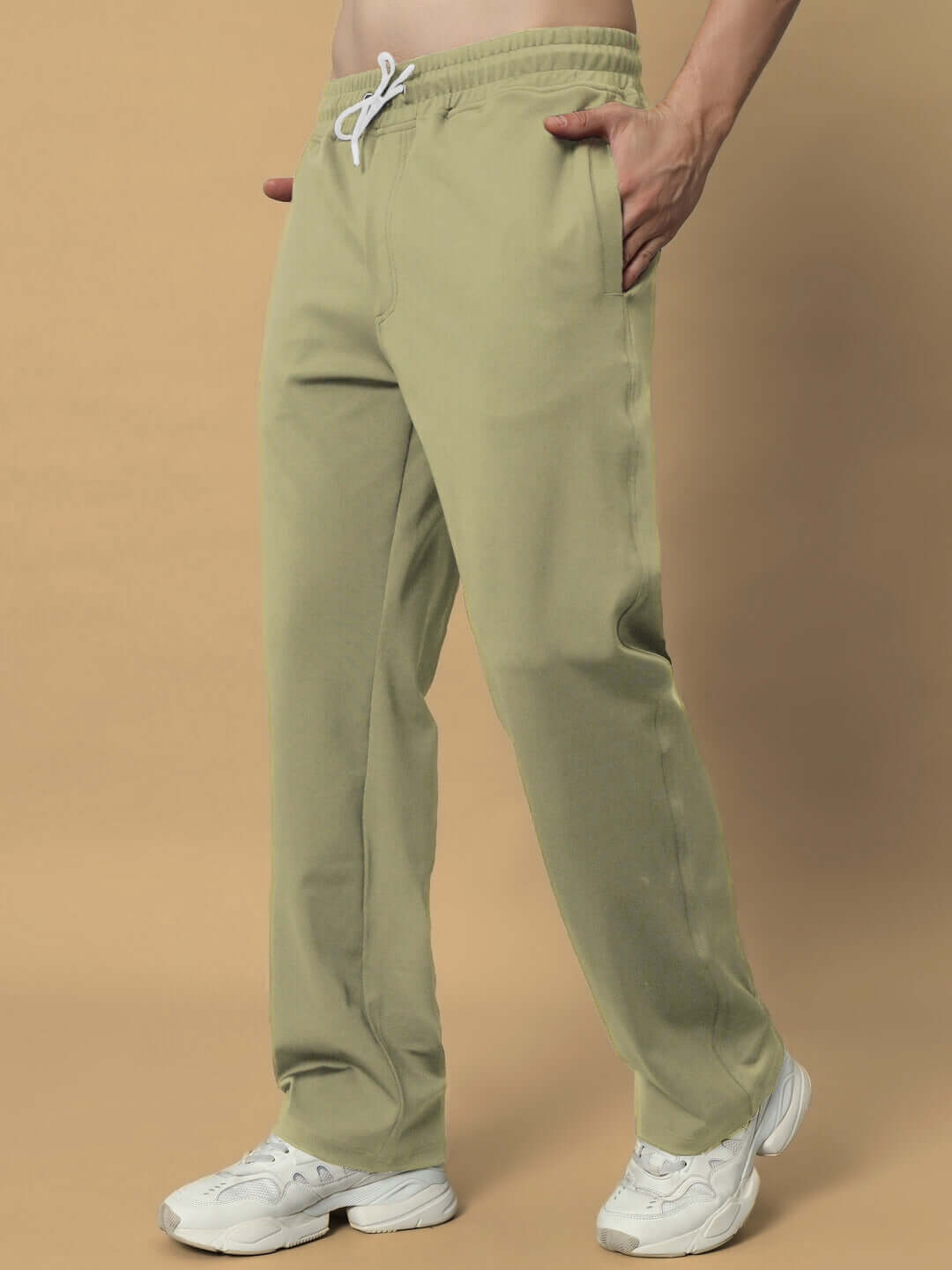 Olive green relaxed jogger pants with drawstring waist, styled with white sneakers.