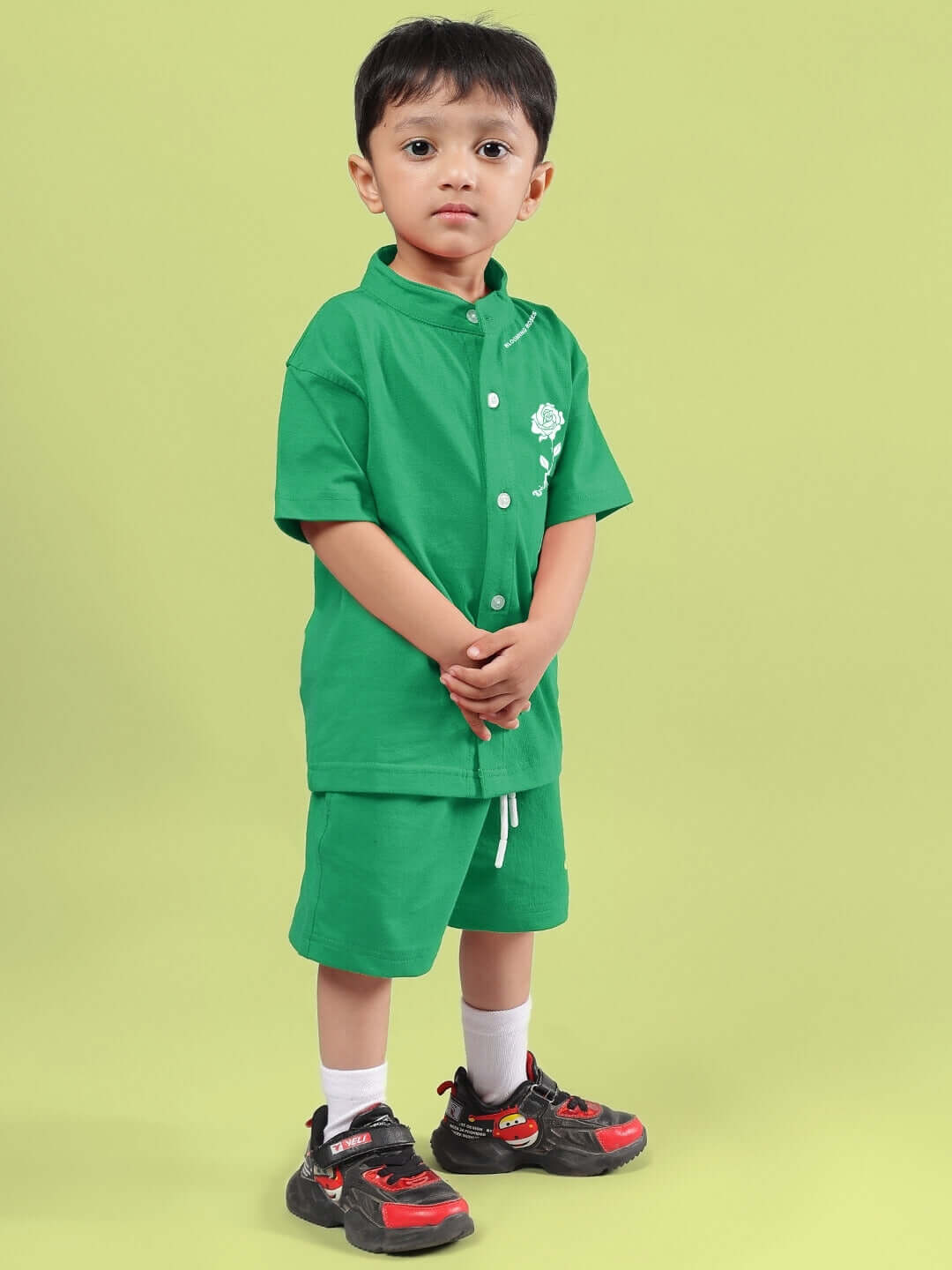Child wearing LIMBO CO-ORD FOR BOYS & GIRLS GREEN set featuring a matching green shirt and shorts on a light green background.