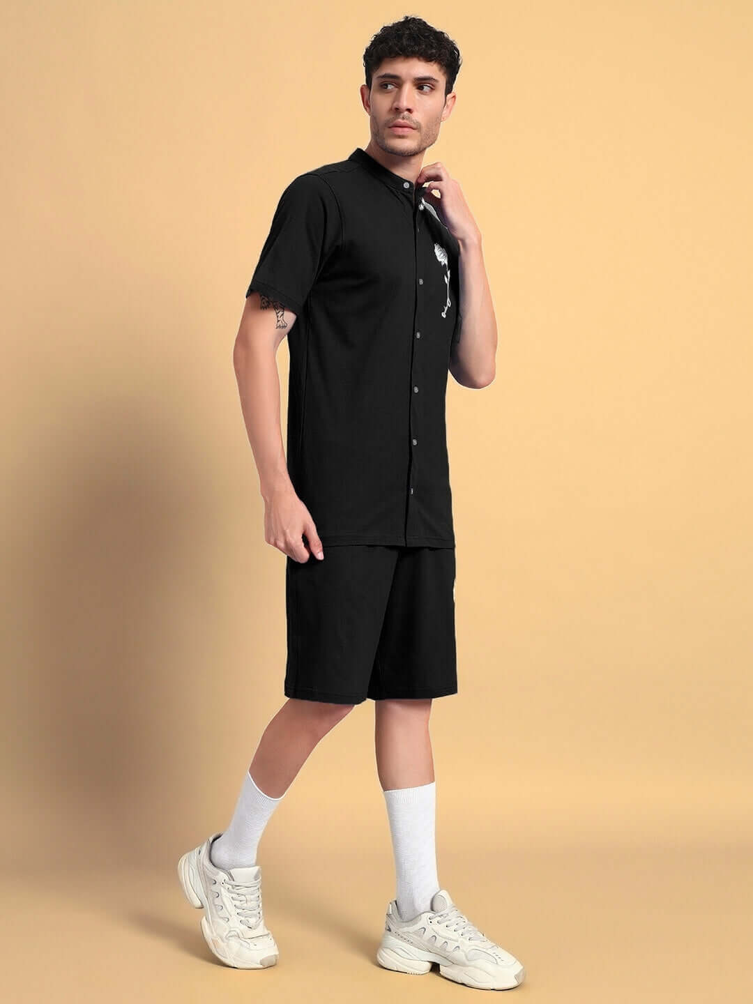 Model wearing LIMBO CO-ORD Set in Black, made from premium cotton terry, standing against a beige background, showcasing a stylish outfit.